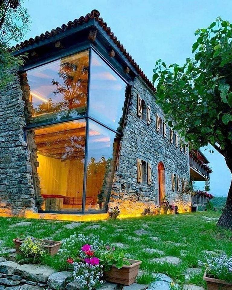 This wonderful double floor glassed corner on this modern stone house