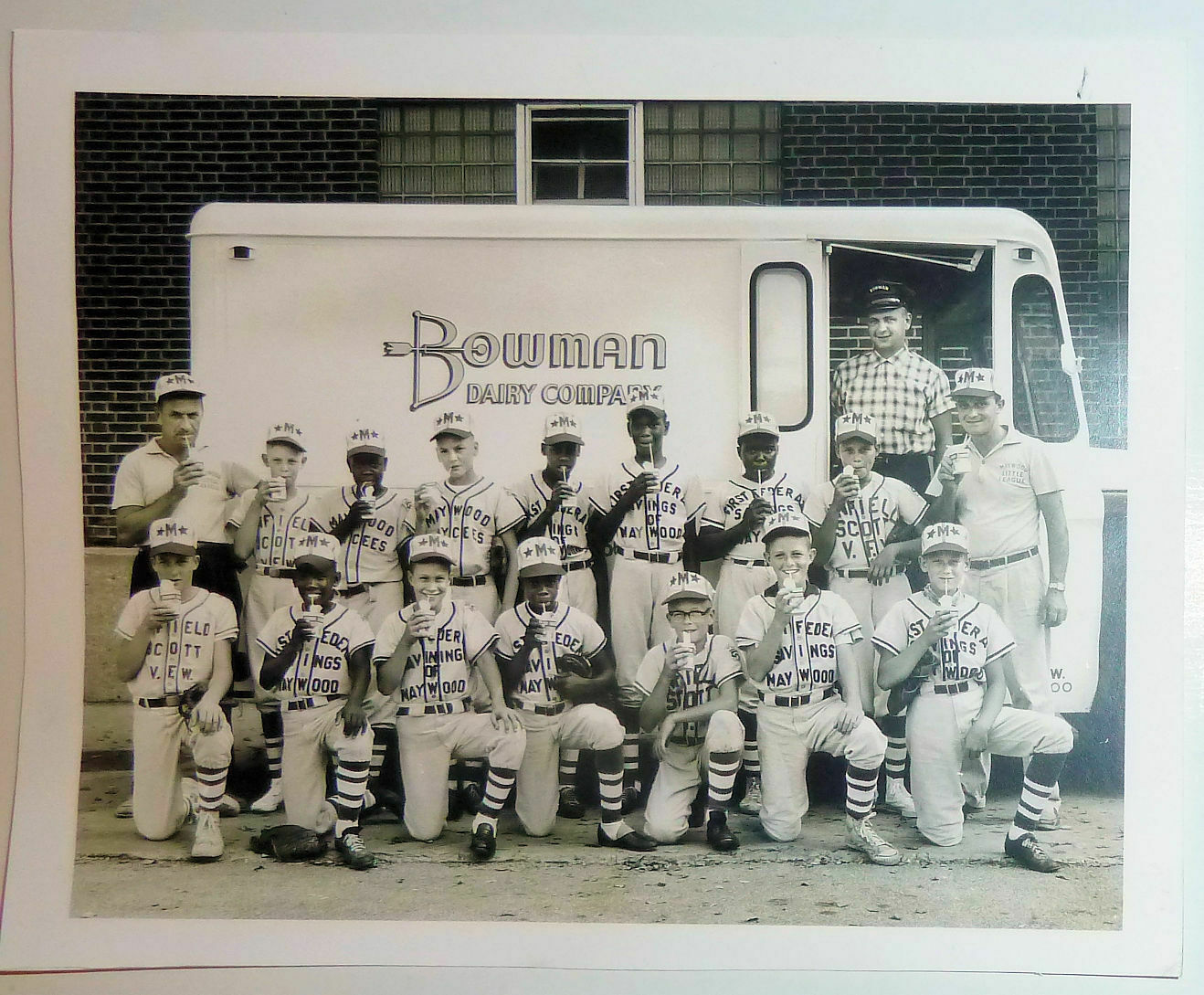 Here is a photo of a little league baseball team standing in front of a