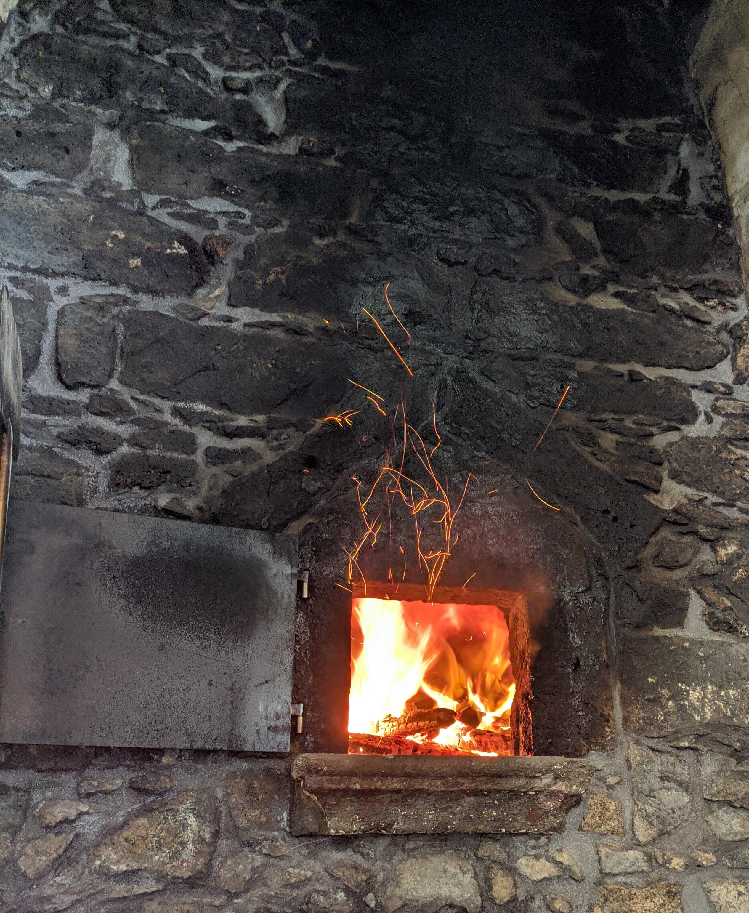 Fire sparkles on the wood oven before bread baking r/mildlyinteresting