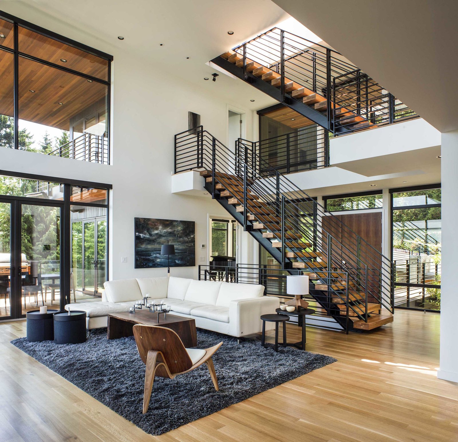 Doubleheight living area with metal staircase in a residence designed