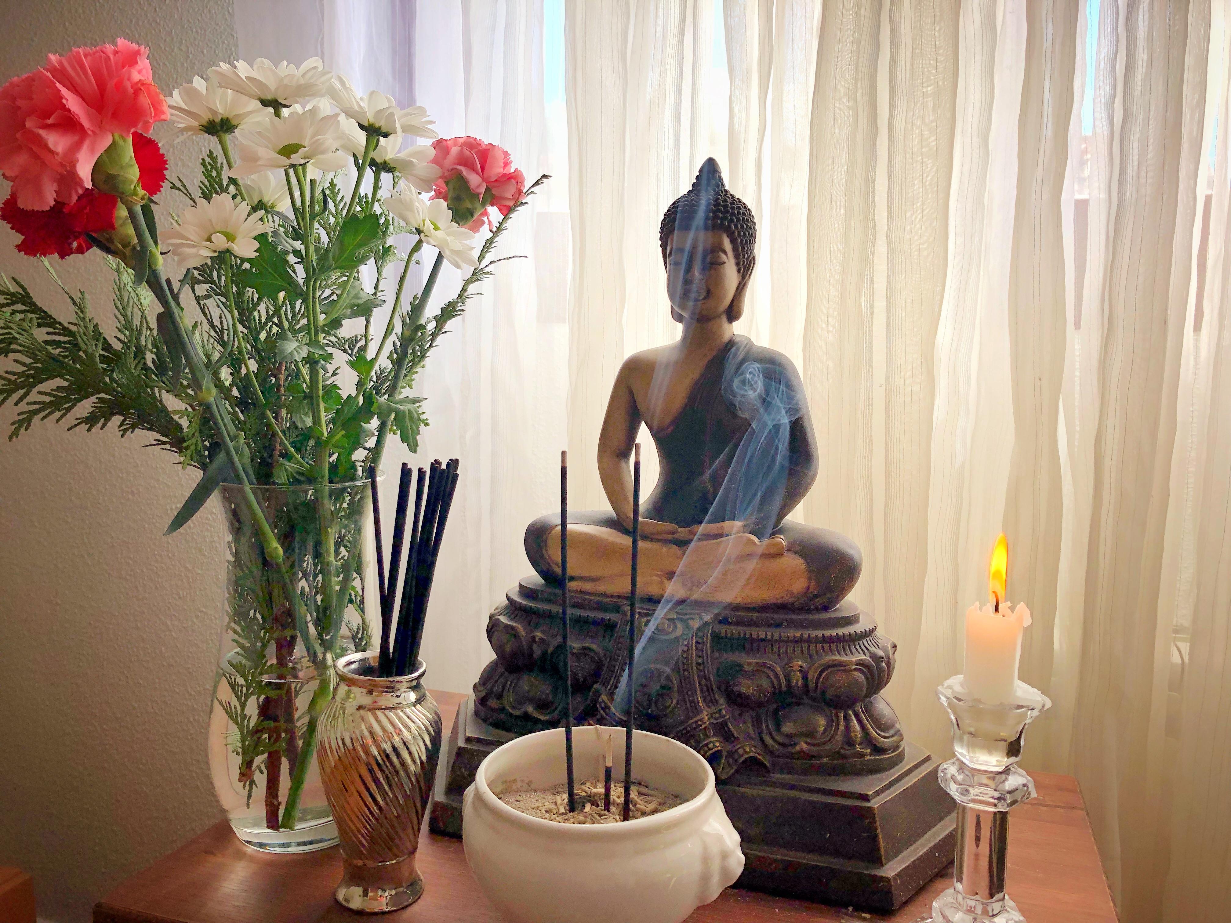 Buddha altar with fresh flowers and incense. Today we’re celebrating