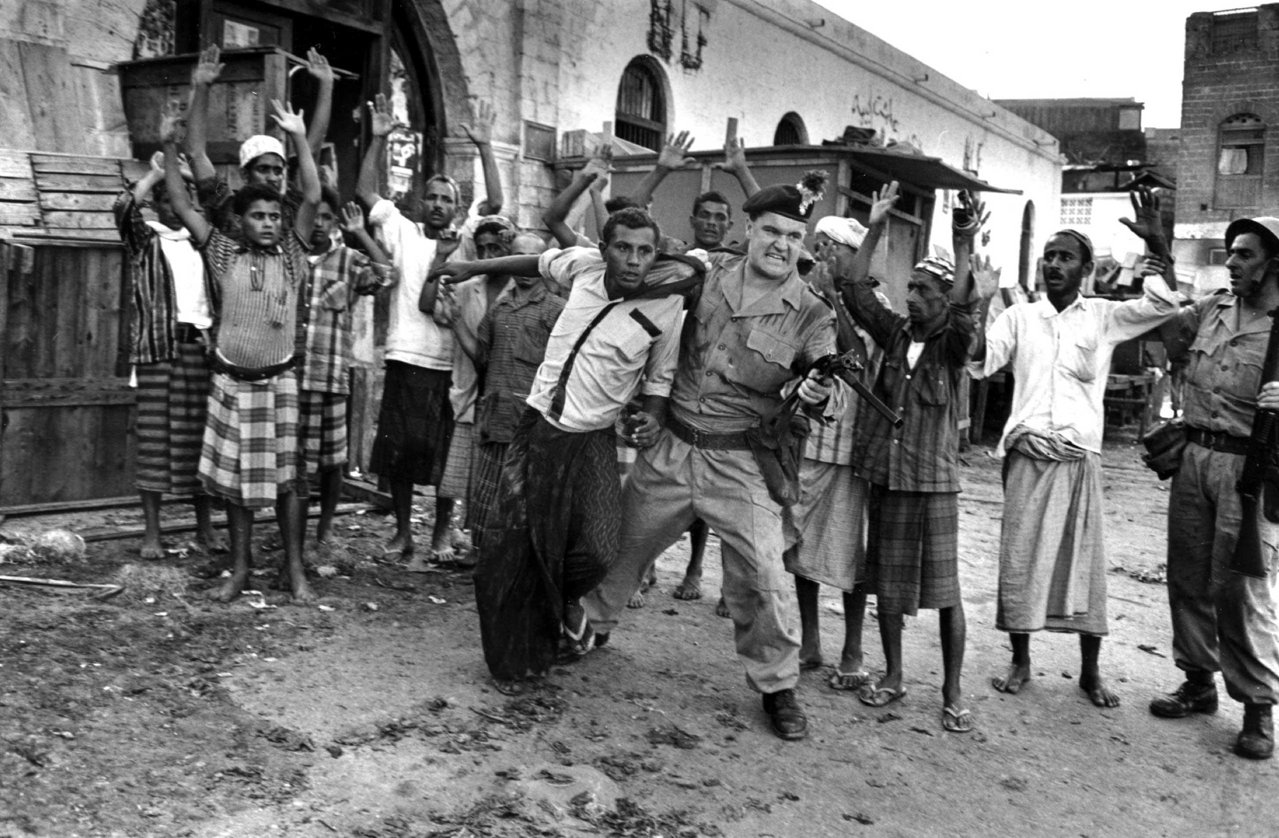 A soldier from the Northumberland Fusiliers pulls a man out of a crowd