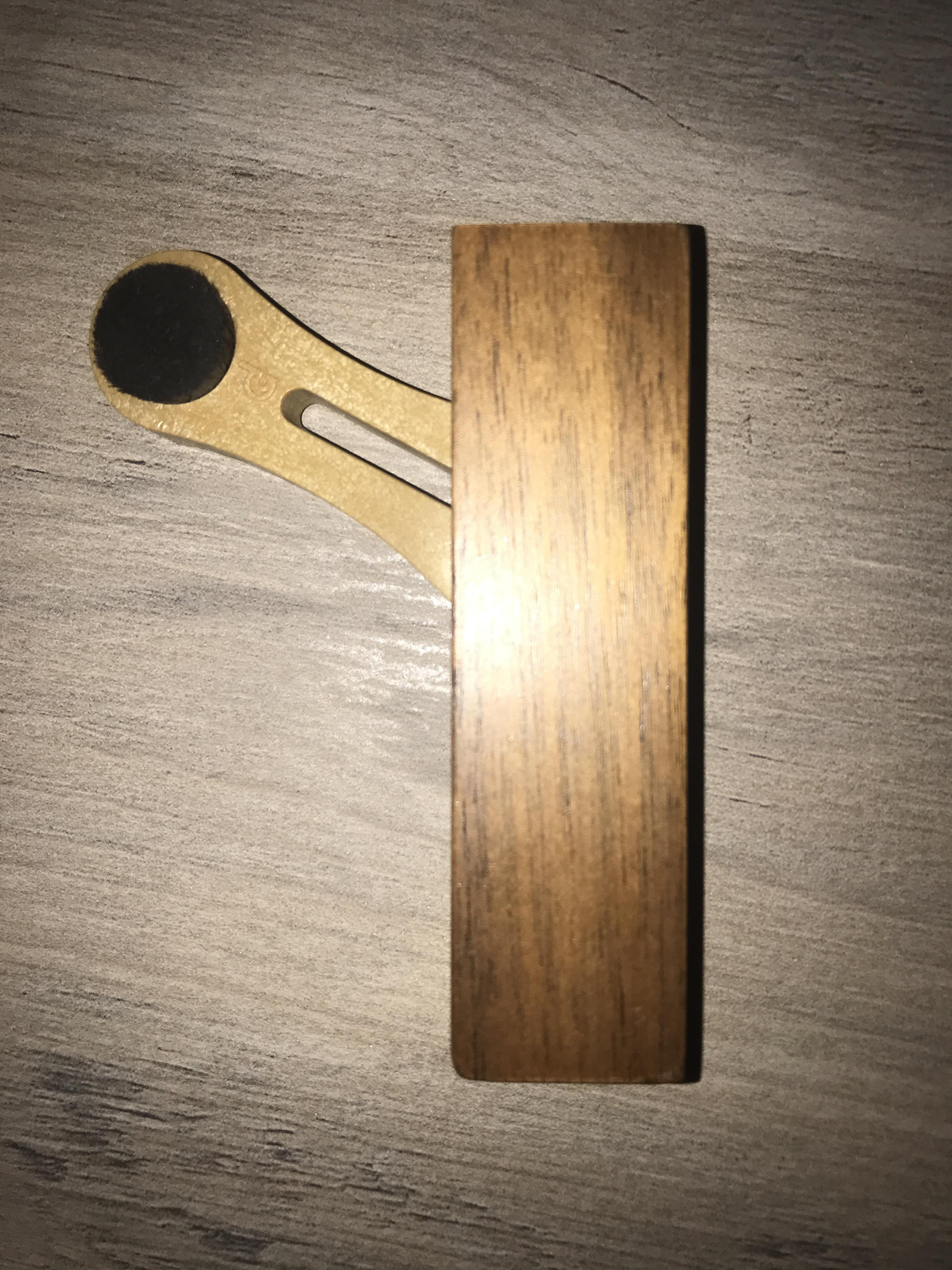 Small sliding wooden block. Has a really small, dense brush on one side, a small mirror on the