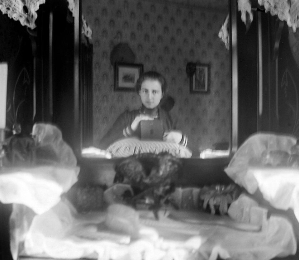 Young girl tries to take a self portrait with a box camera 1901