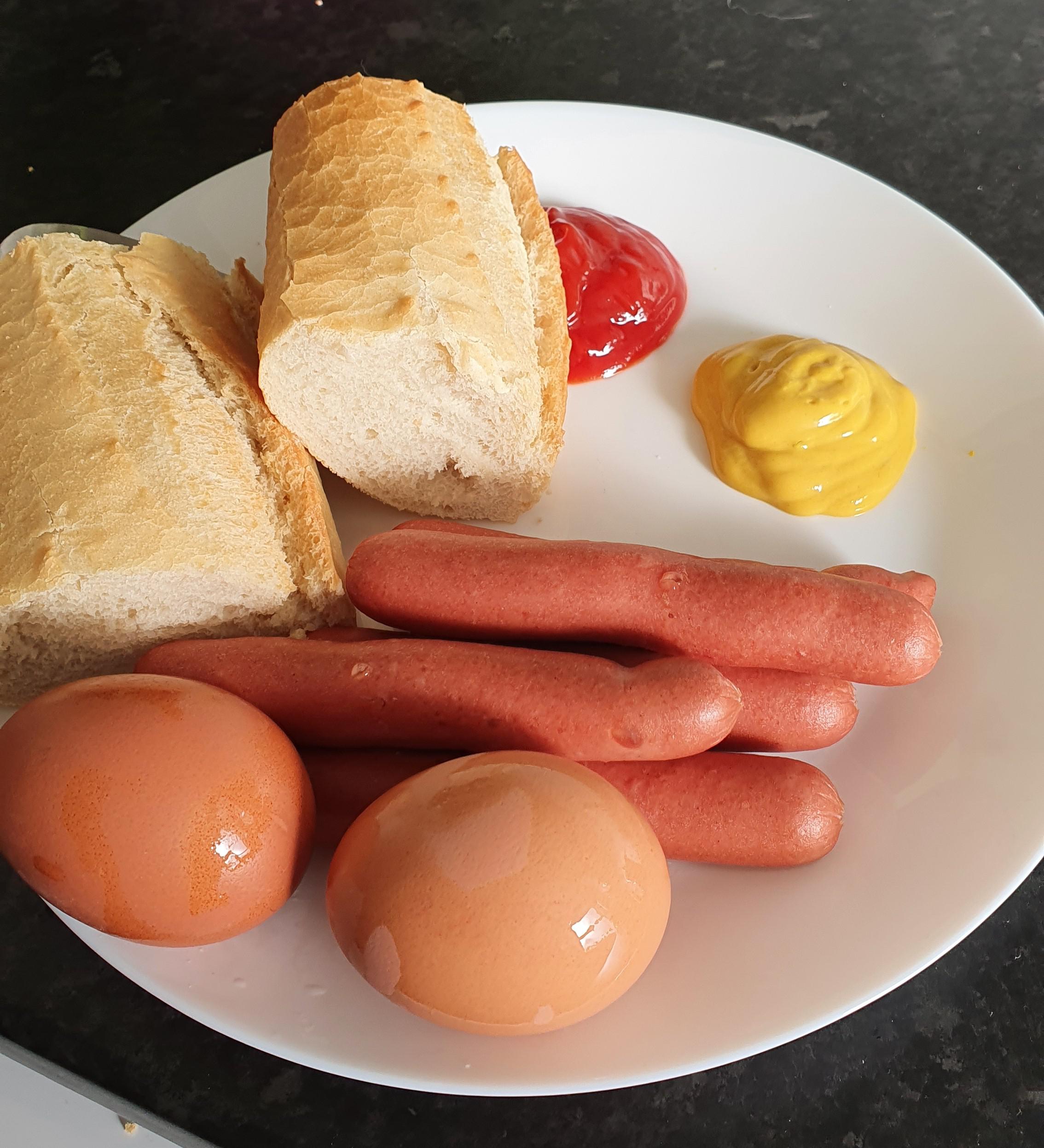 Deconstructed hot dogs with two hard boiled eggs on the side (all
