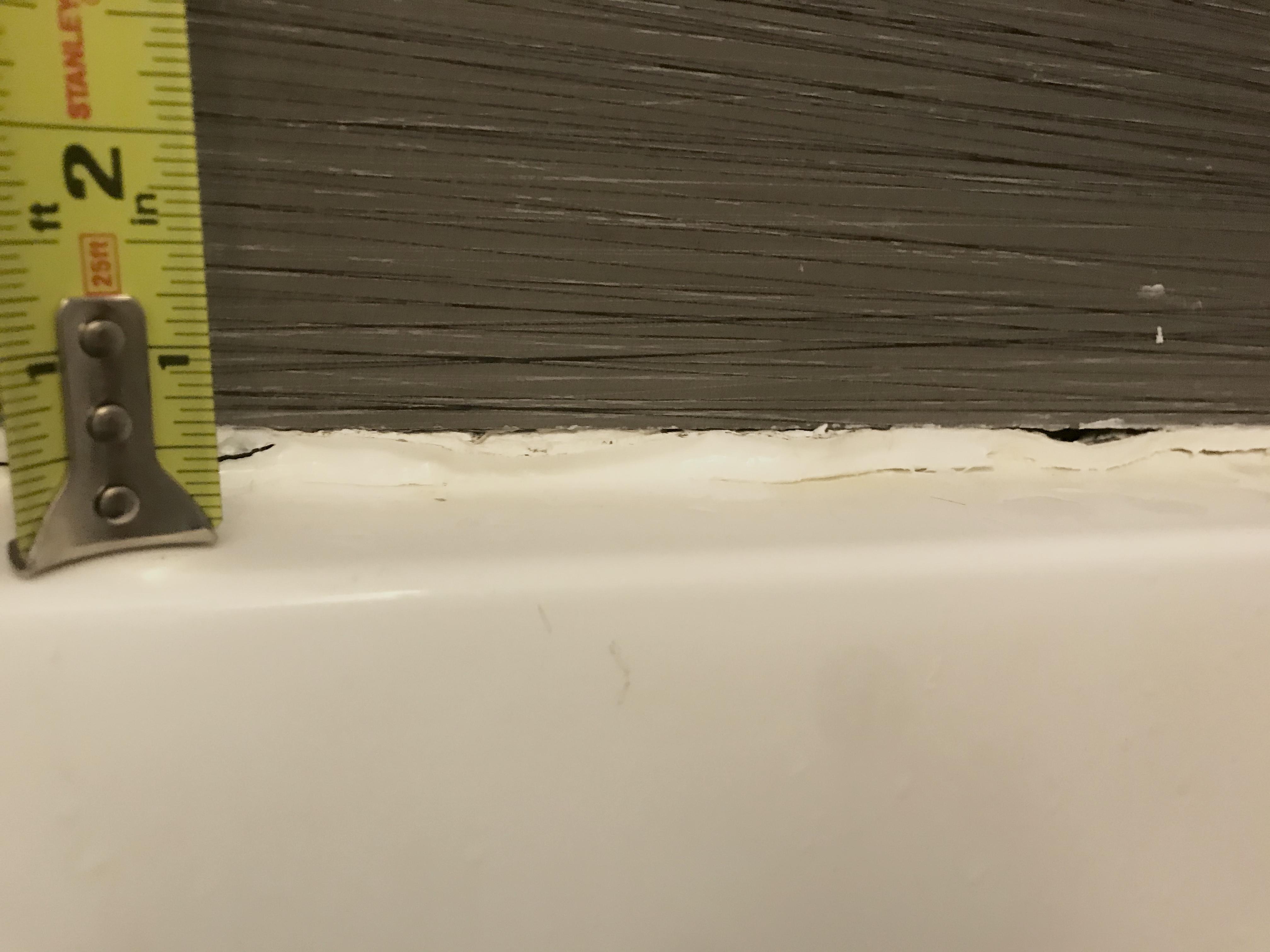 How can I fill the 0.5in. gap between tub and tile? Tried caulking it