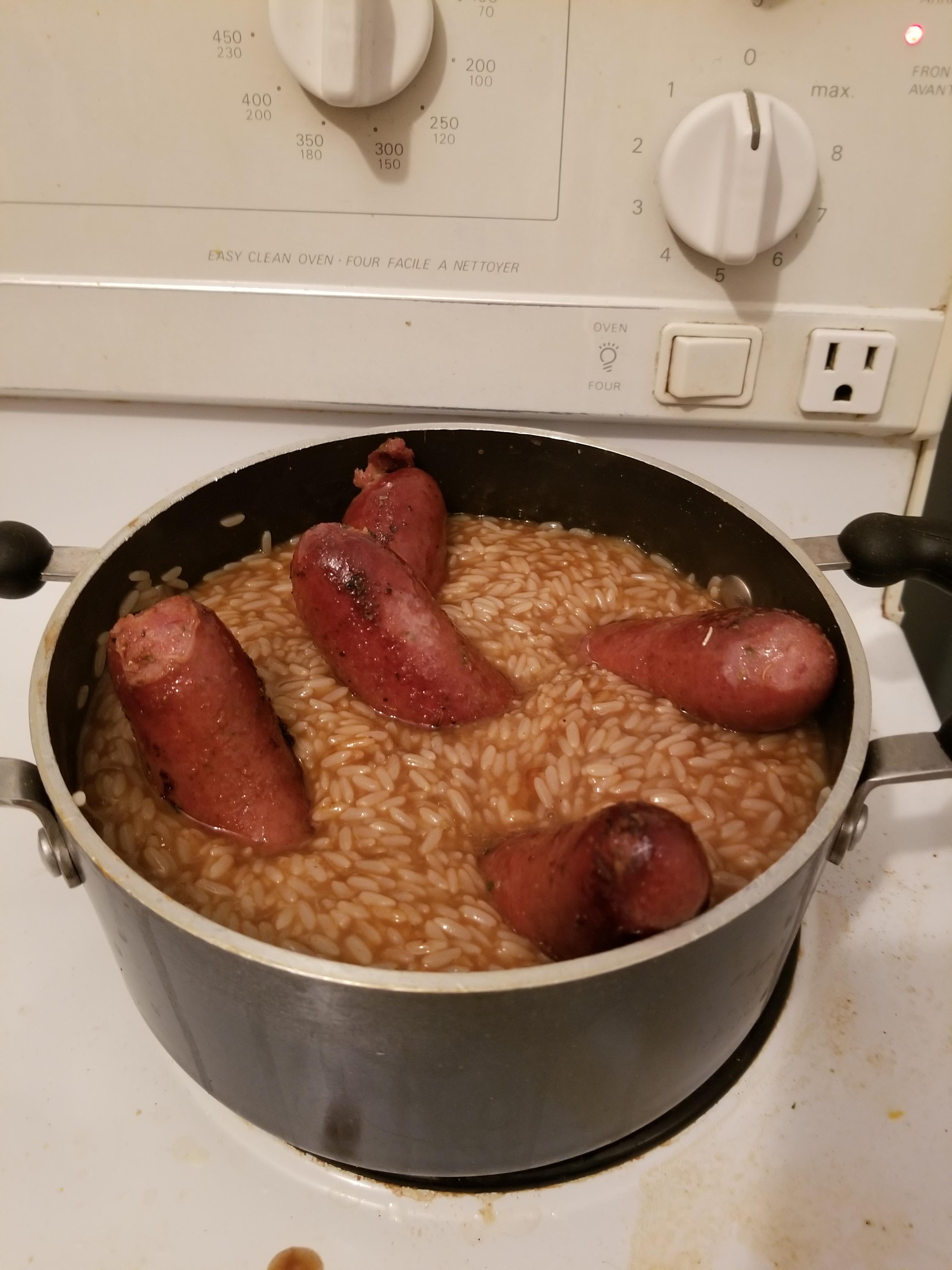 Sausages in rice with gravy, unchopped. Gravy has bbq and hot sauce