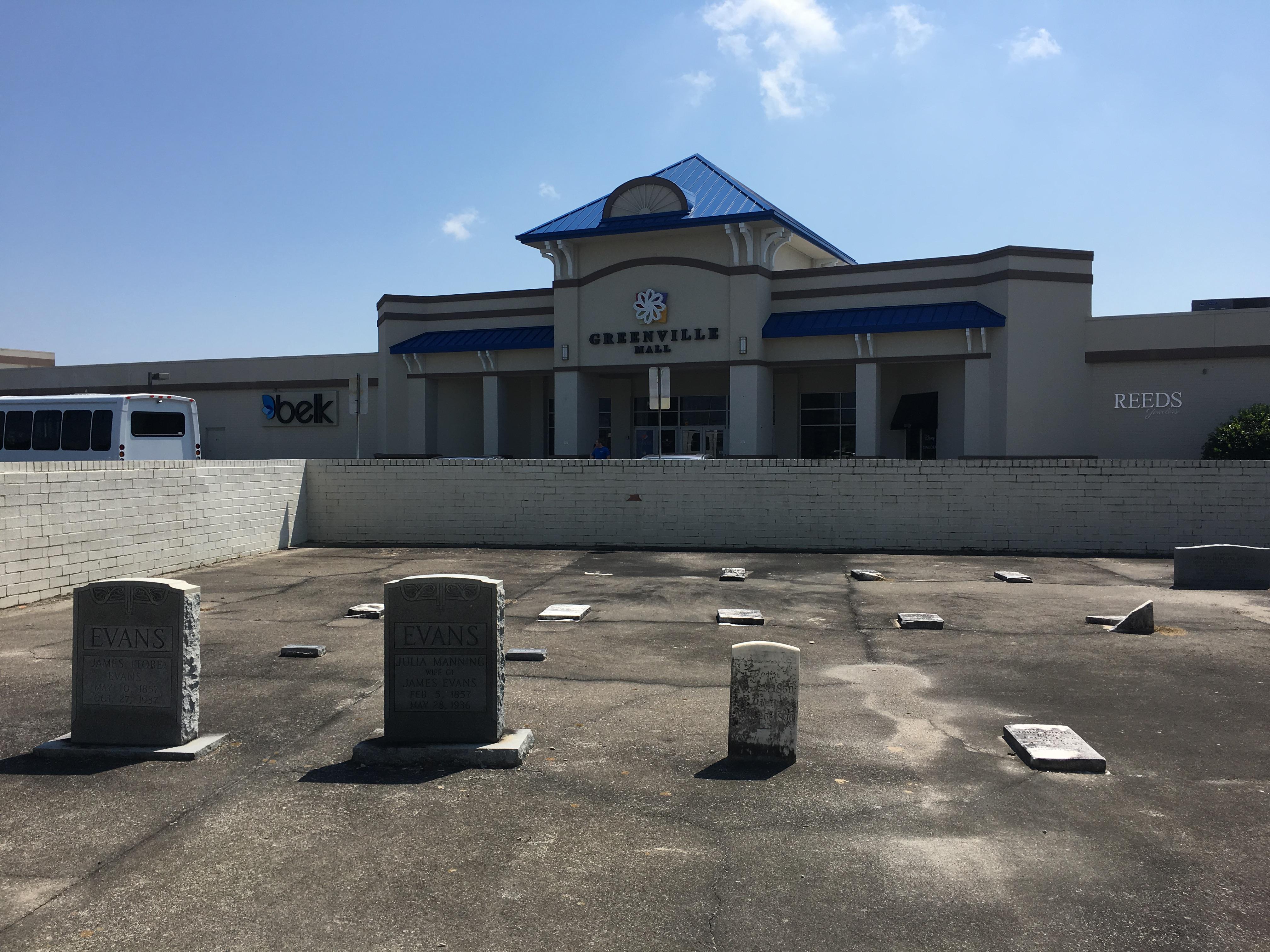 There is a paved over cemetery in the middle of this mall parking lot