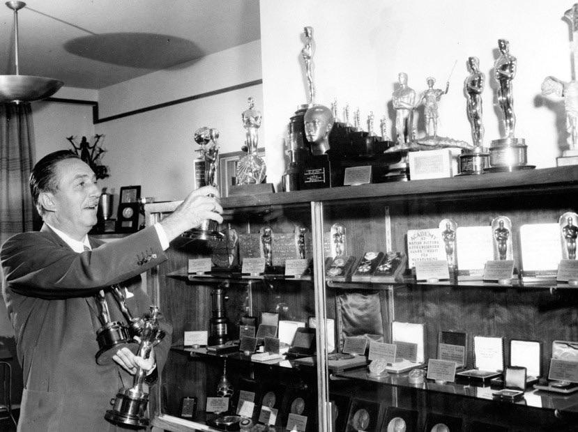 Walt Disney with his Oscar awards. He is credited with winning the most Oscars in history. In