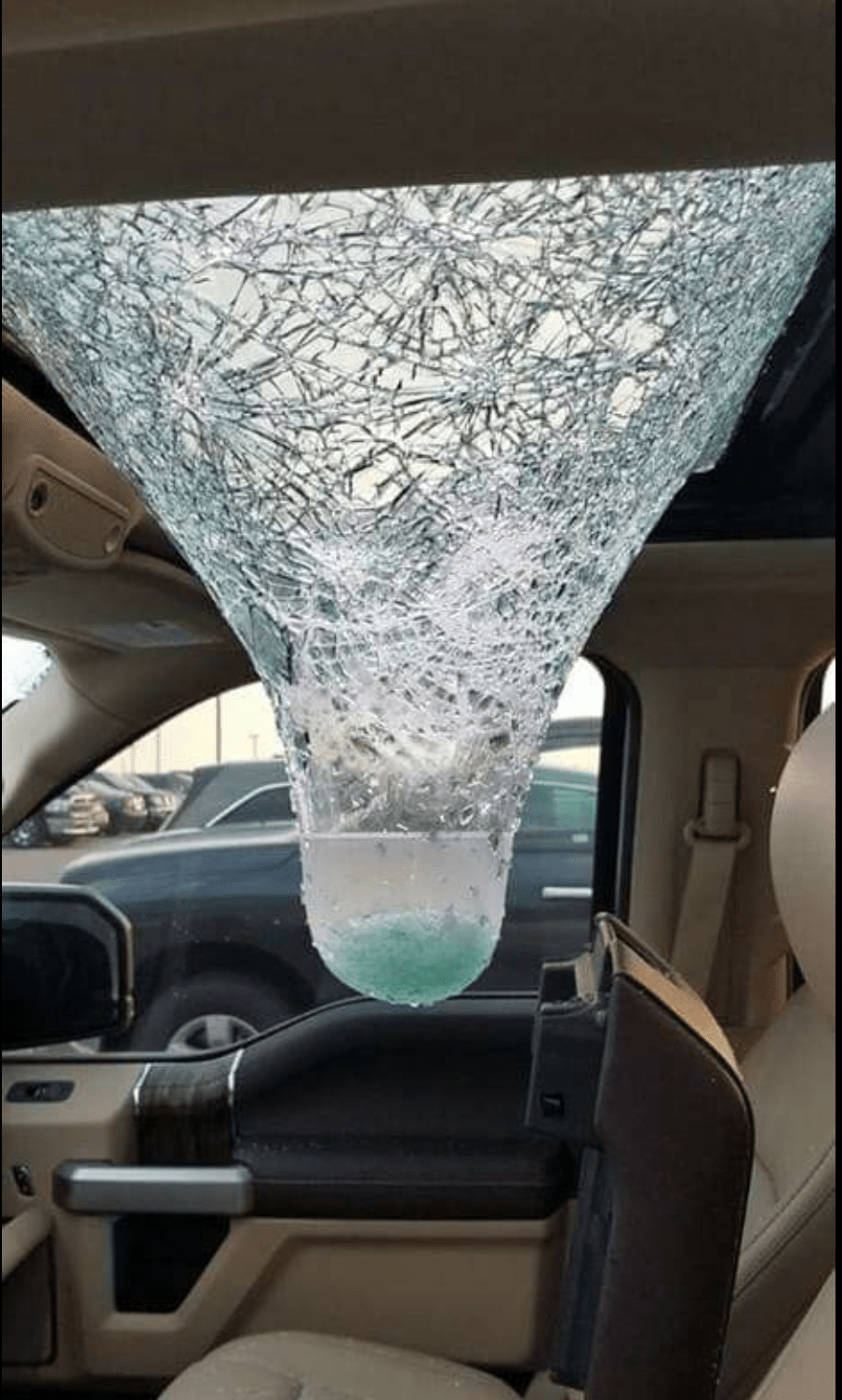 A shattared laminated sun roof after a hail storm r/natureismetal