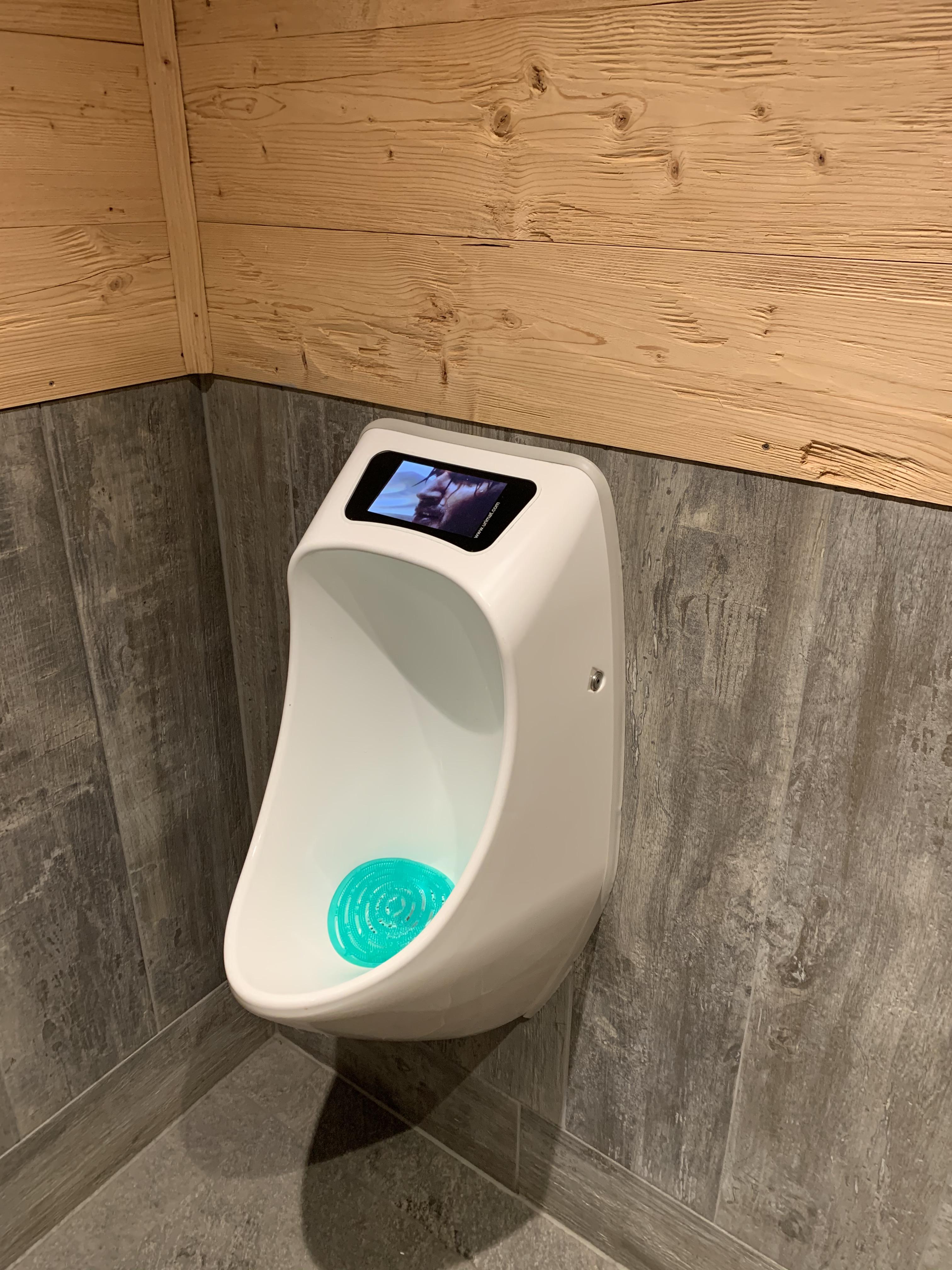 This waterless urinal has an LCD screen embedded. A "green" solution to