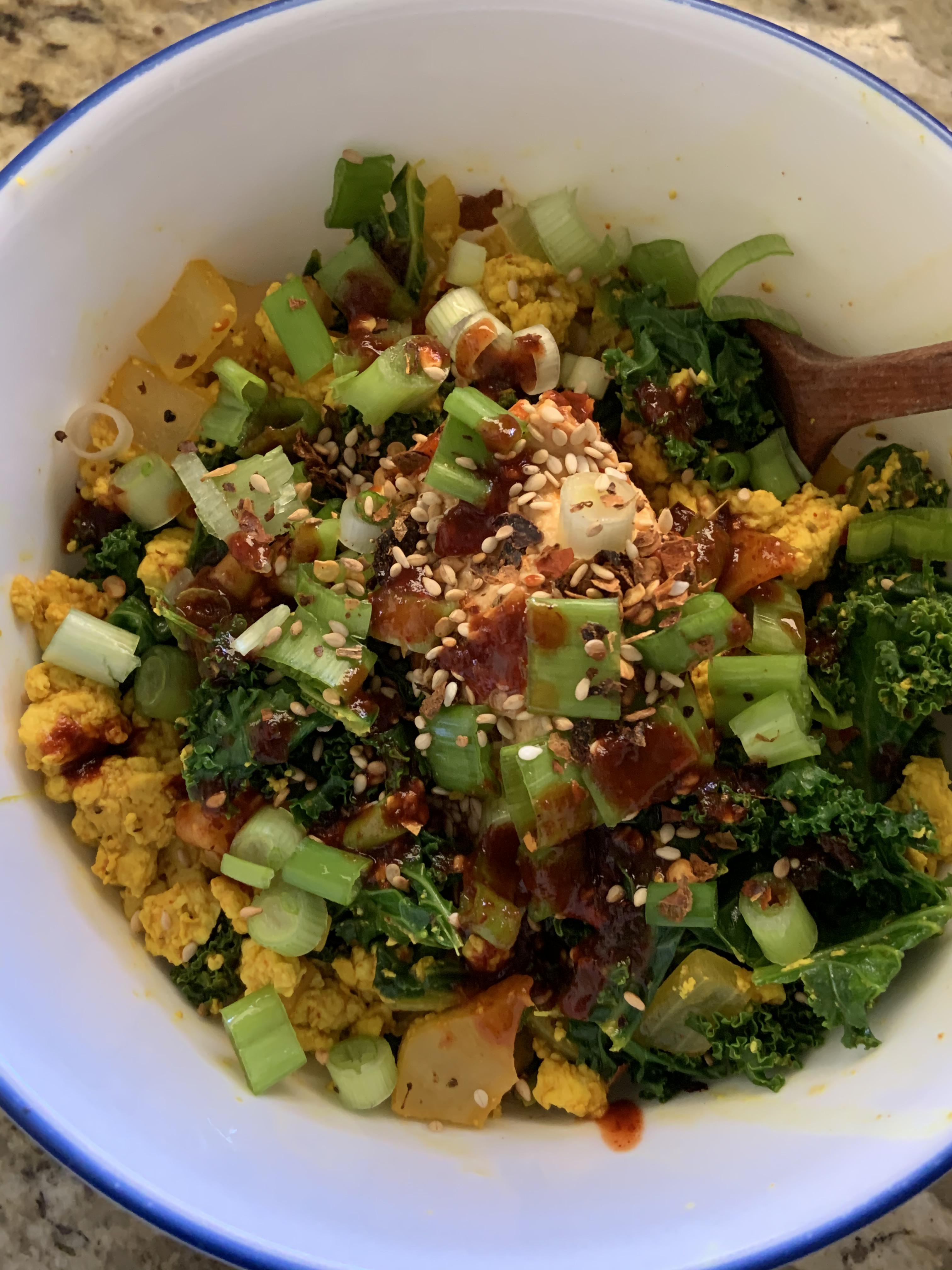 Kale kimchi tofu scramble topped w red pepper hummus, green onions