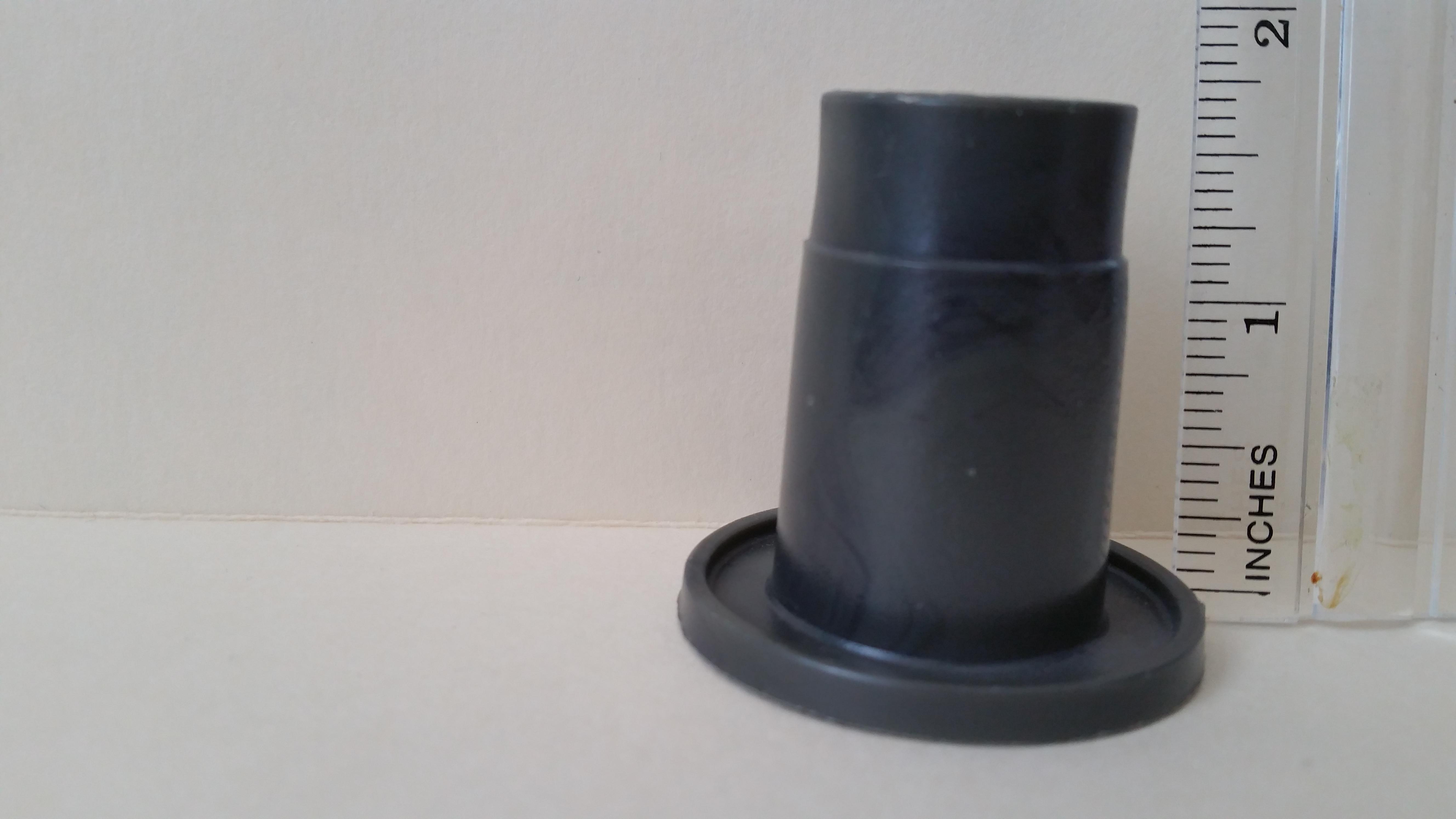 Hard black plastic with circular foot and depression in top piece. I