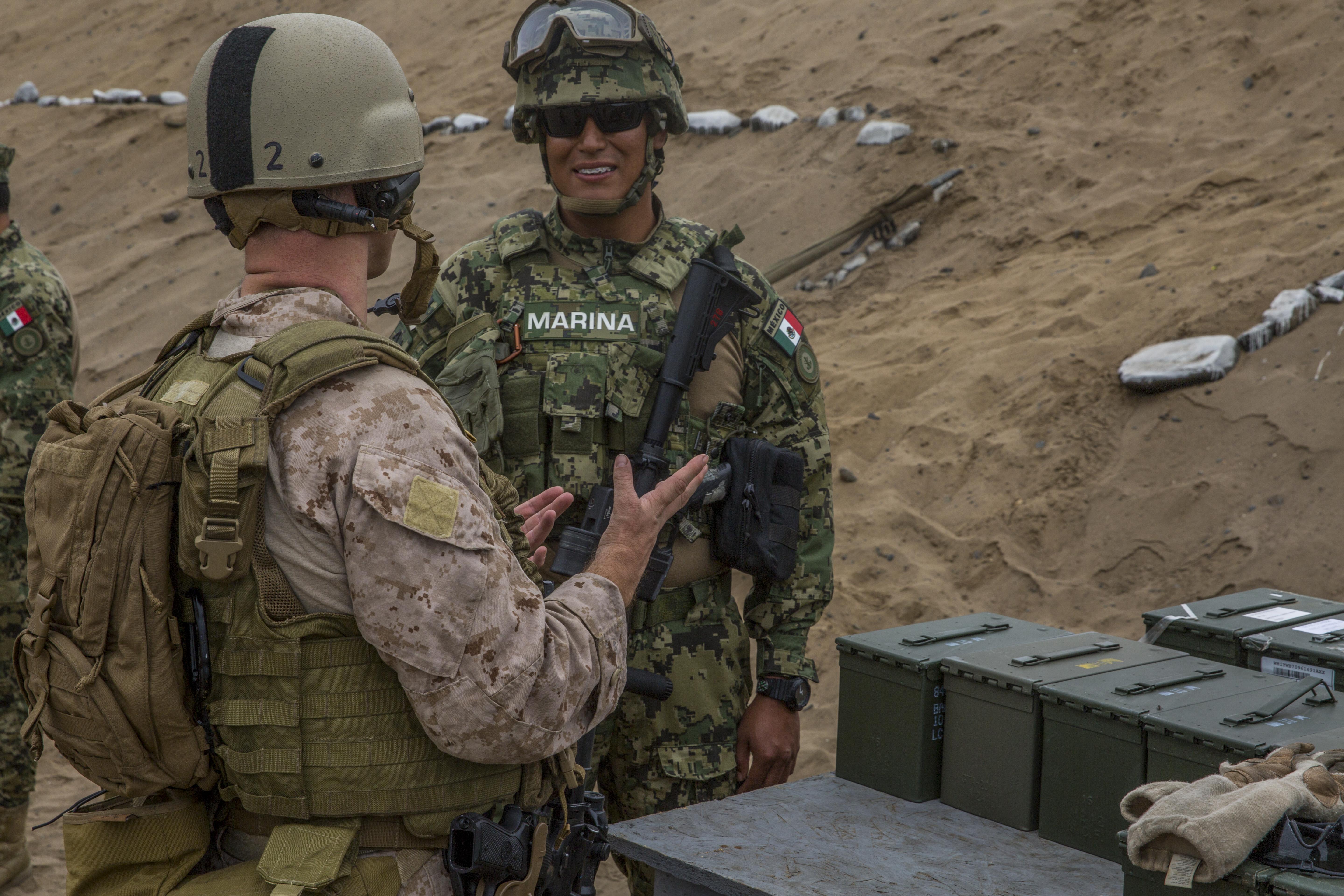 A U.S Marine and a Mexican Marine discuss shooting techniques after