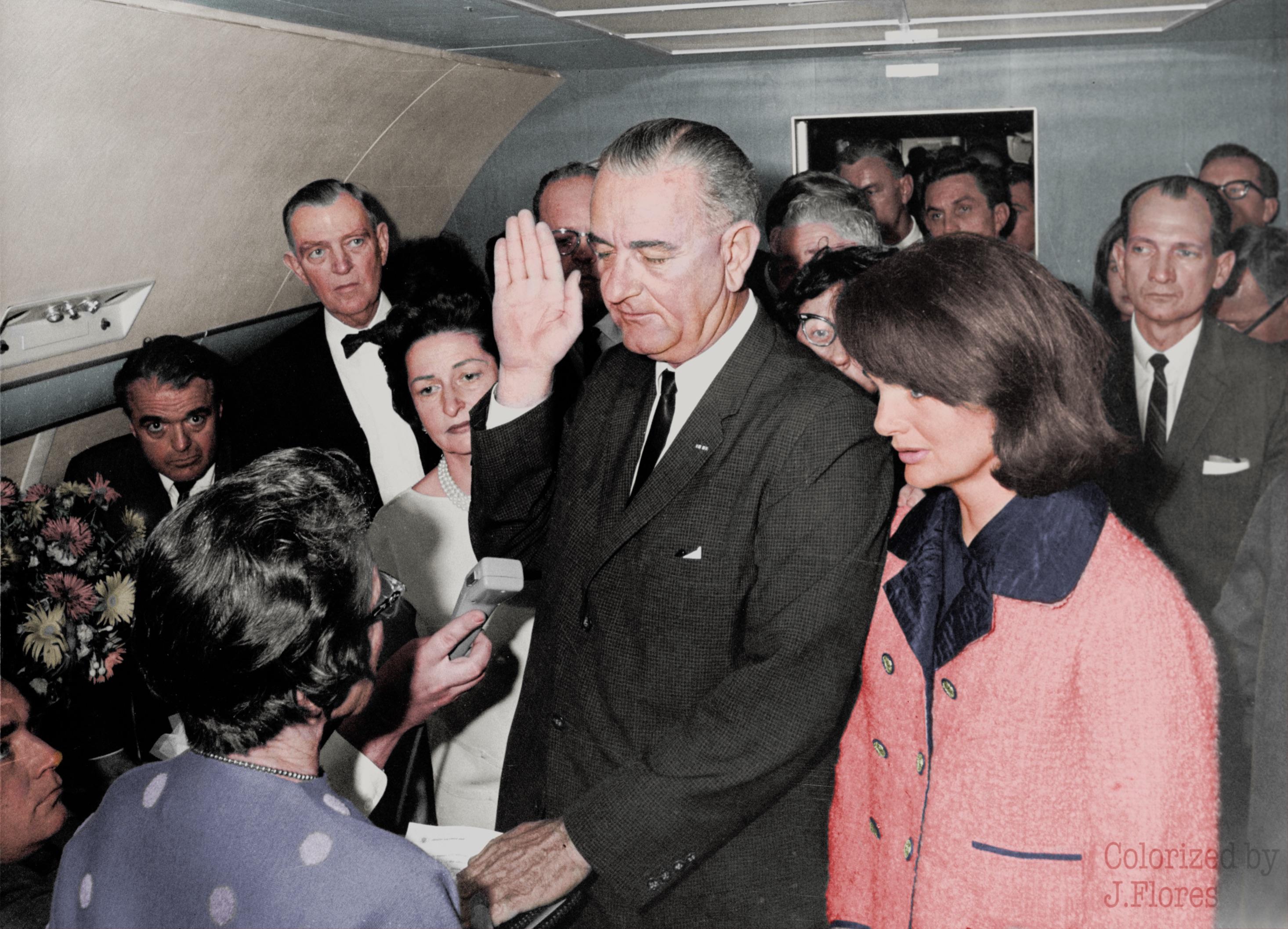 Lyndon B. Johnson signing in as President next to Jacqueline Kennedy