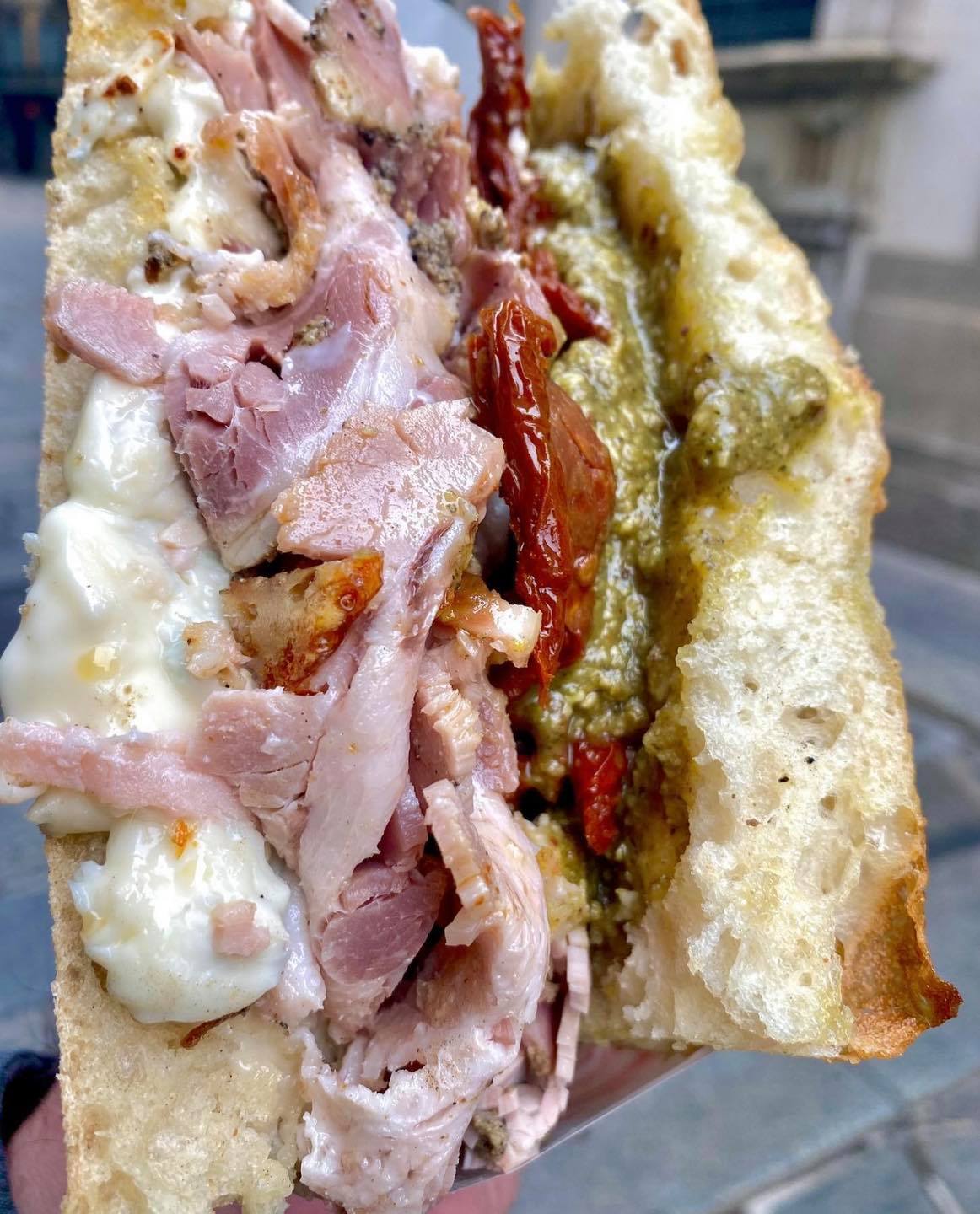 A "schiacciata" sandwich from Milan, filled with sweet porchetta, sundried tomatoes