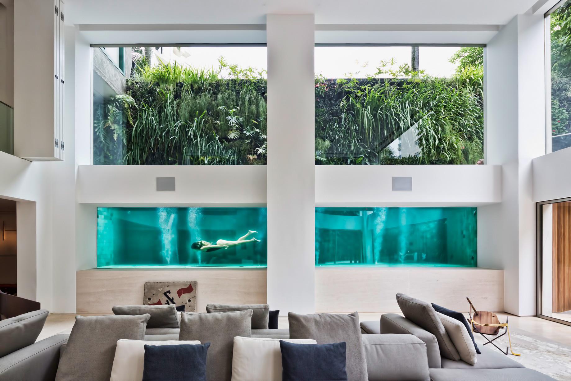 Living room with underwater pool views by Fernanda Marques Arquitetos