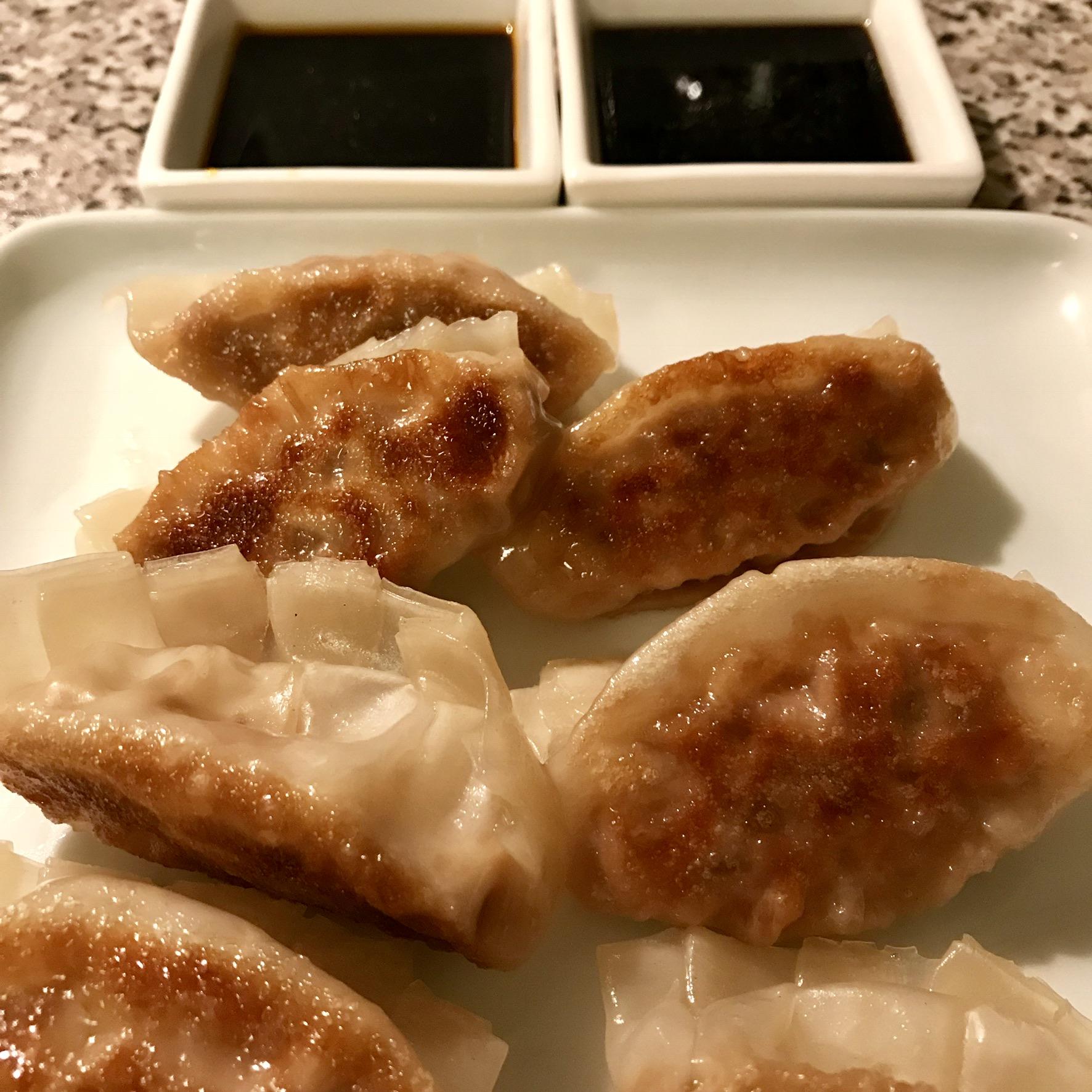 Homemade pork and ginger gyoza with a spicy soy and regular soy dip