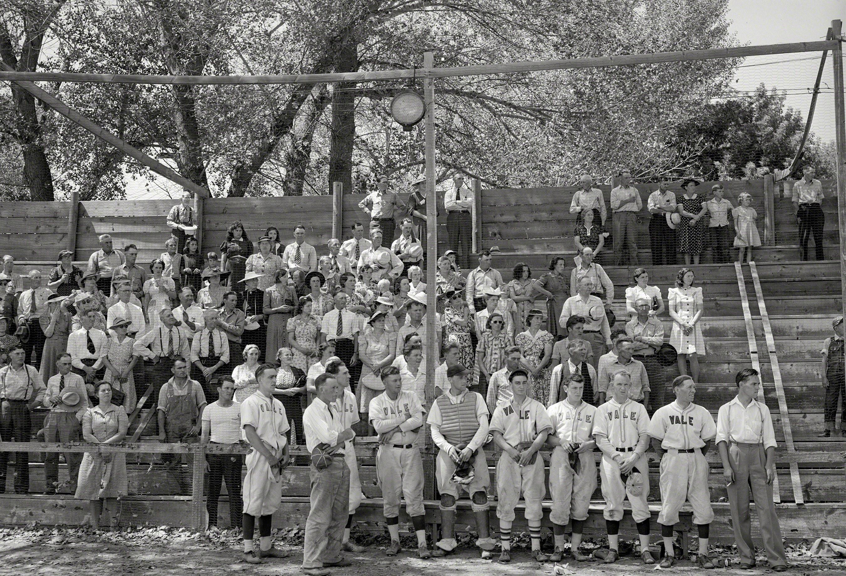 Vale, Oregon. Baseball players and spectators stand at attention while