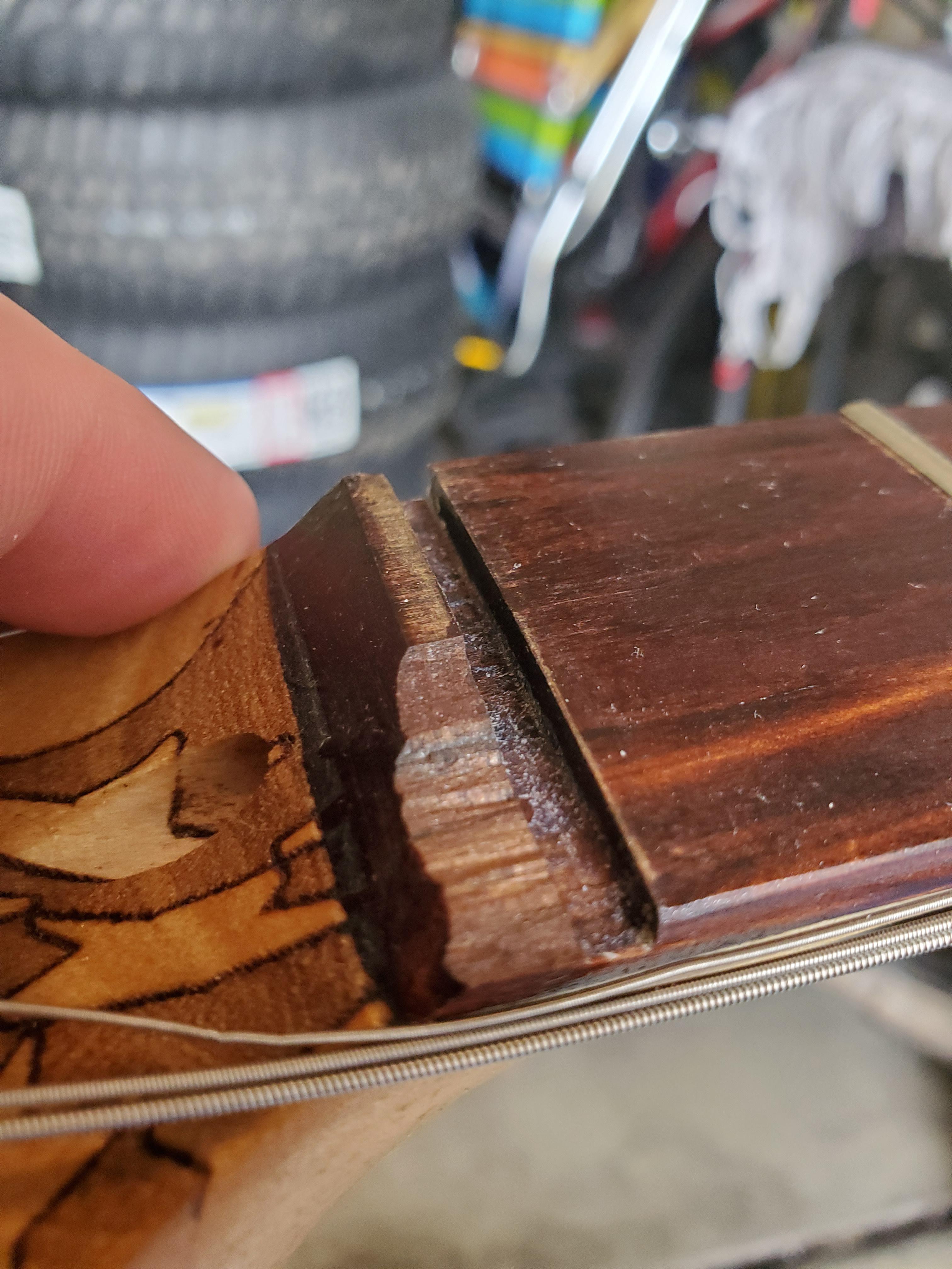 Someone was trying to remove the nut and "the fretboard just exploded