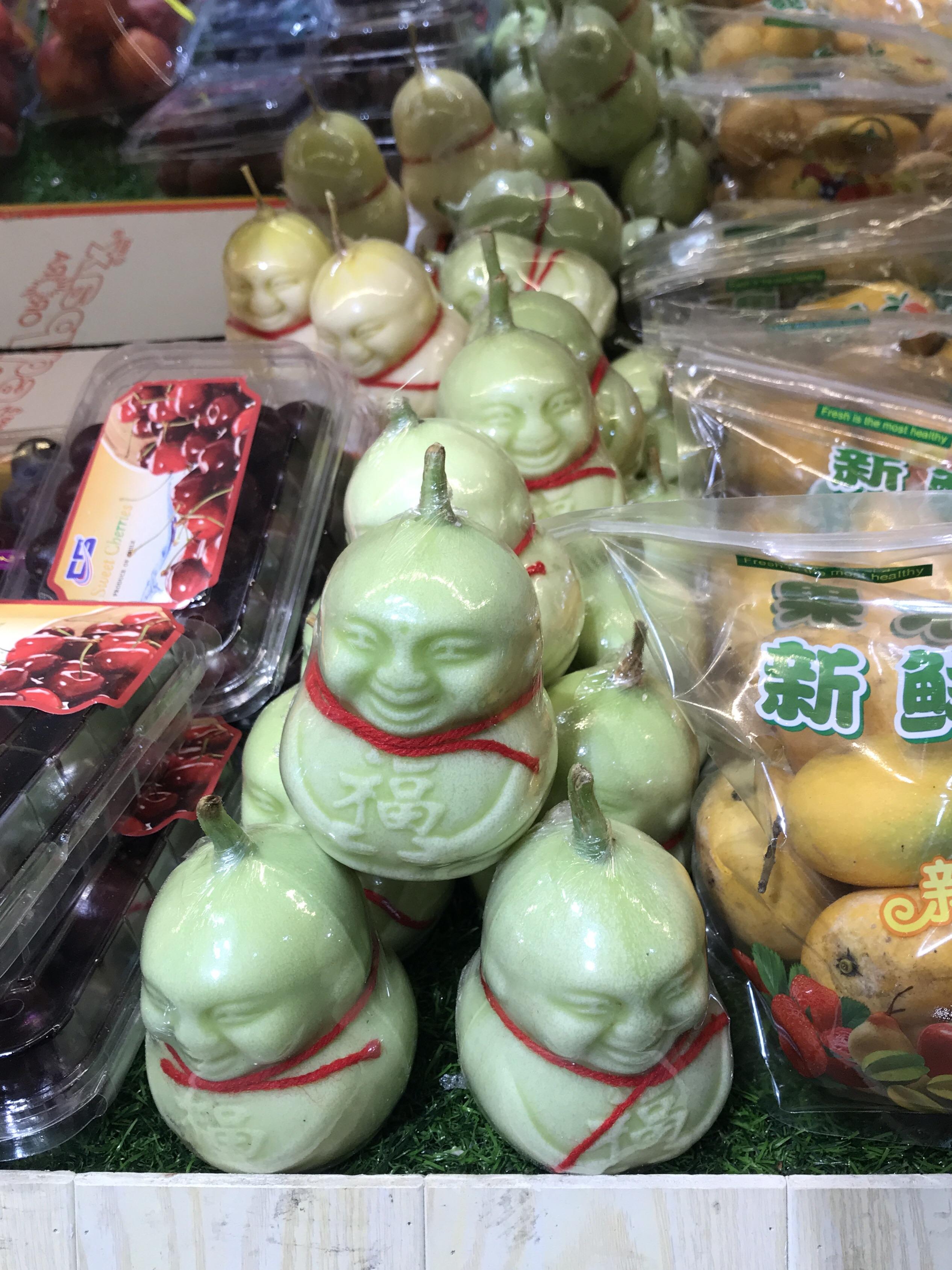 These perfect little Buddha shaped pears in a fruit store in China. r/mildlyinteresting