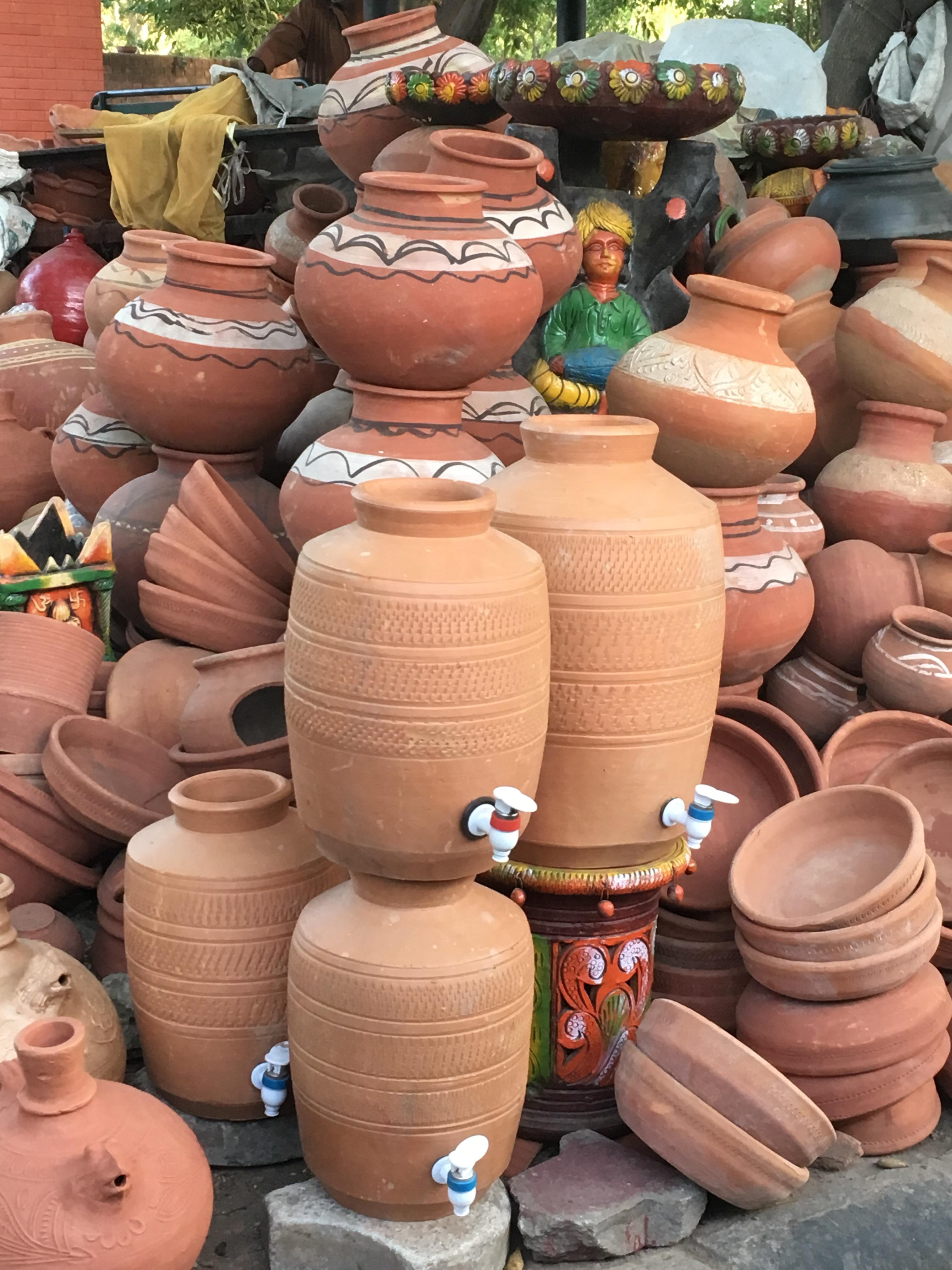 A traditional clay pot for sale modernized with a plastic water