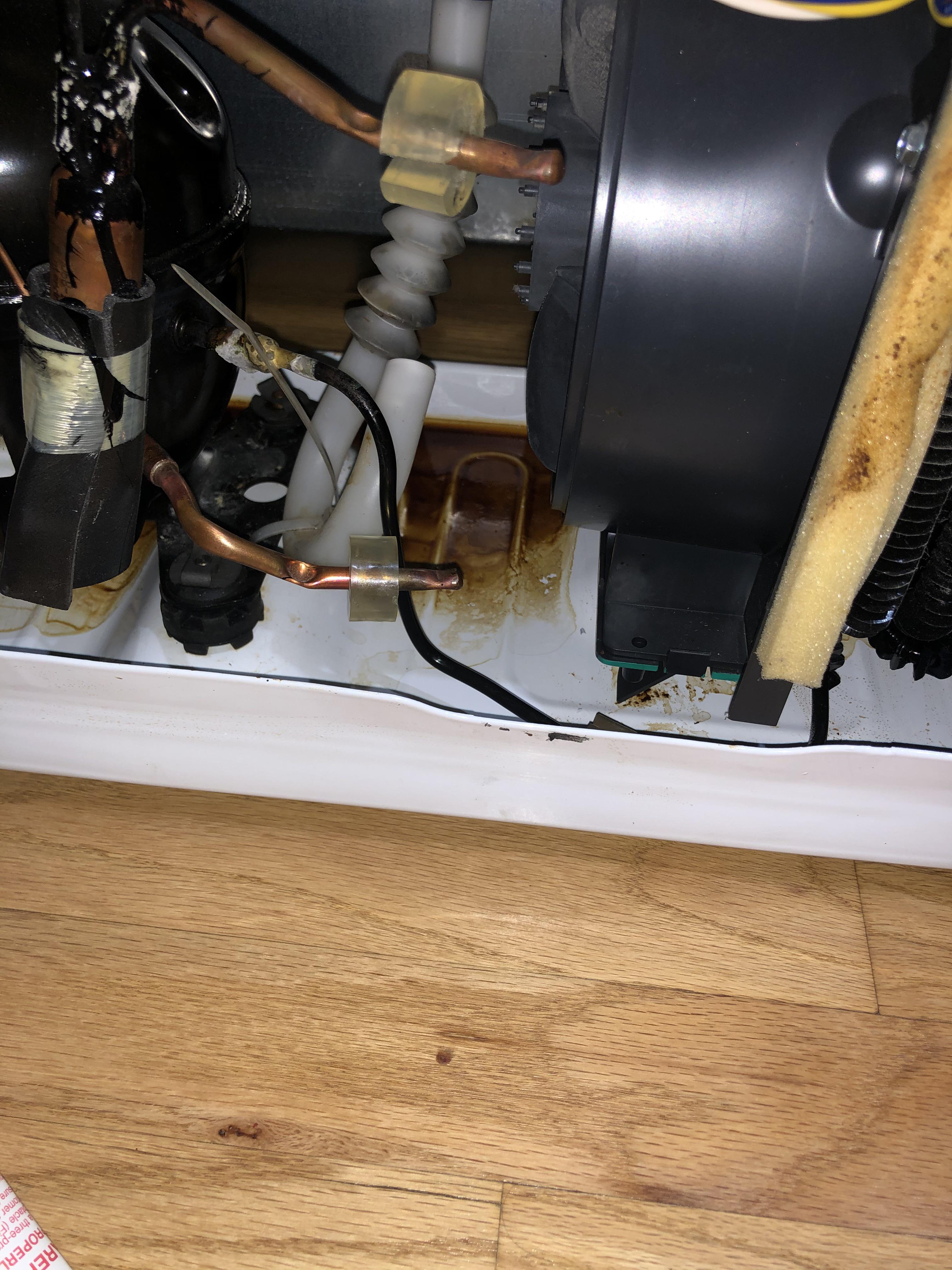 Brown liquid in drip pan causing bad smell refrigerator