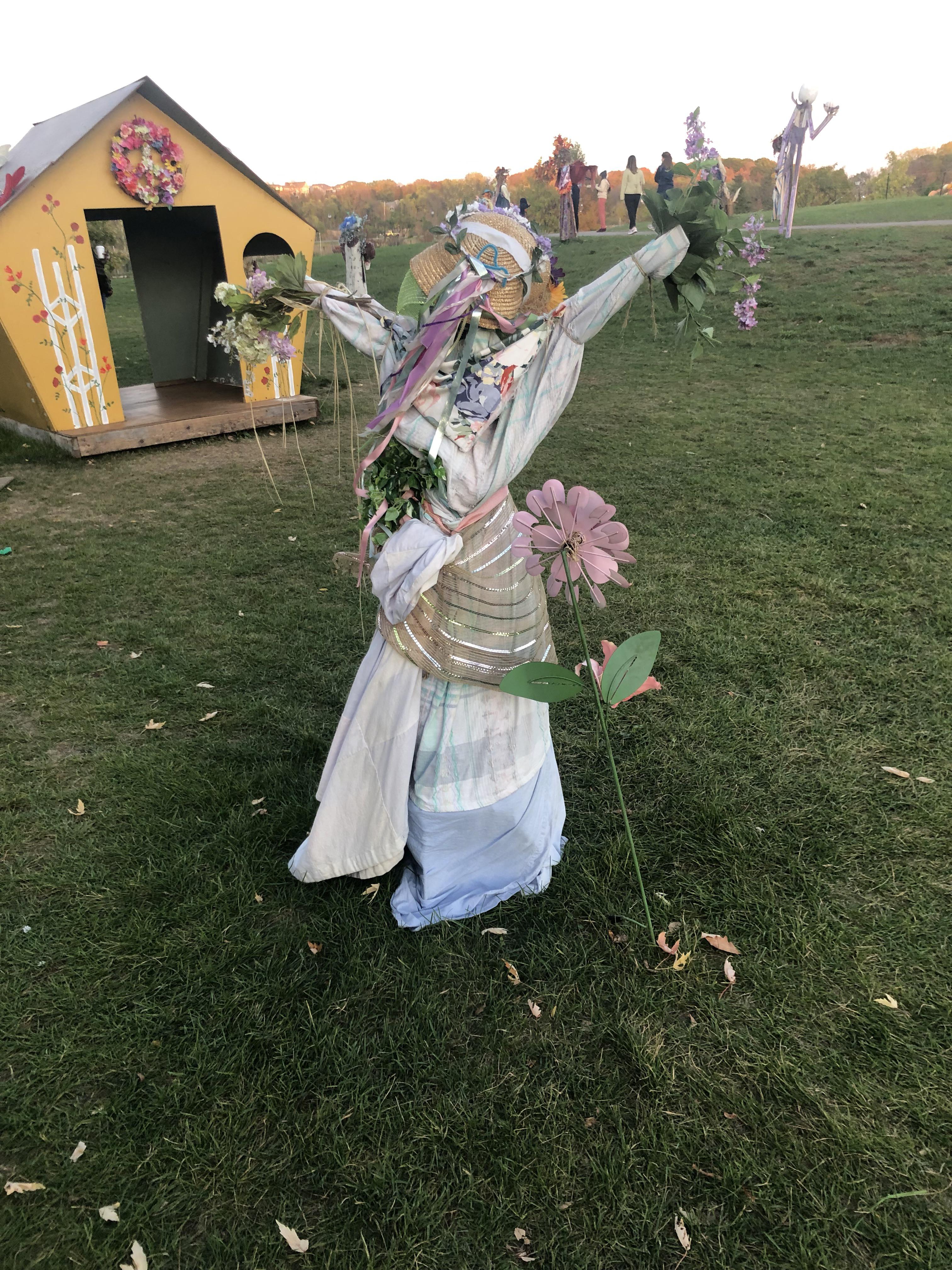 A good girl in a straw hat / with her arms out in a cornfield. r