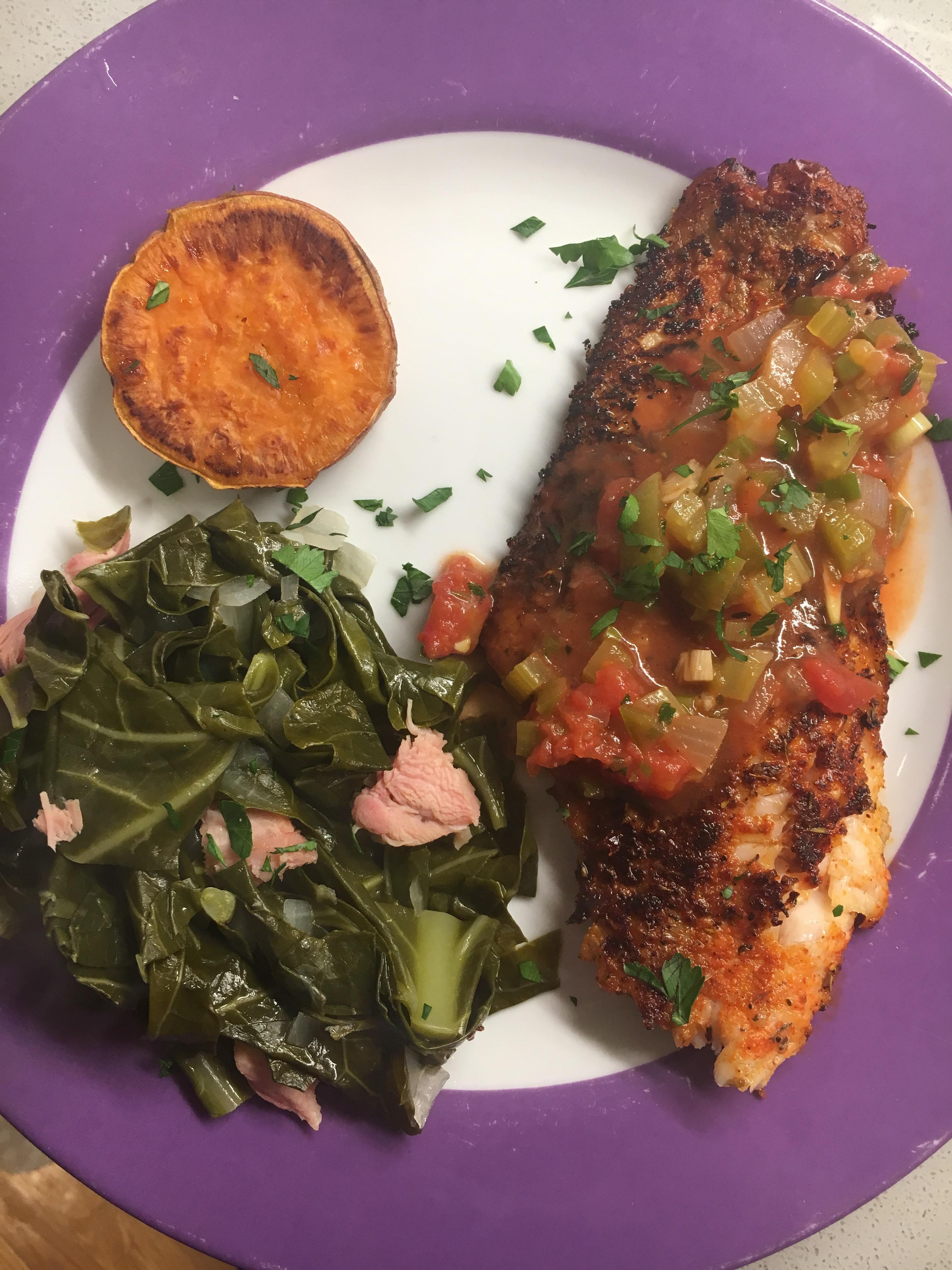 Blackened catfish with creole sauce, collard greens, and baked yam. r