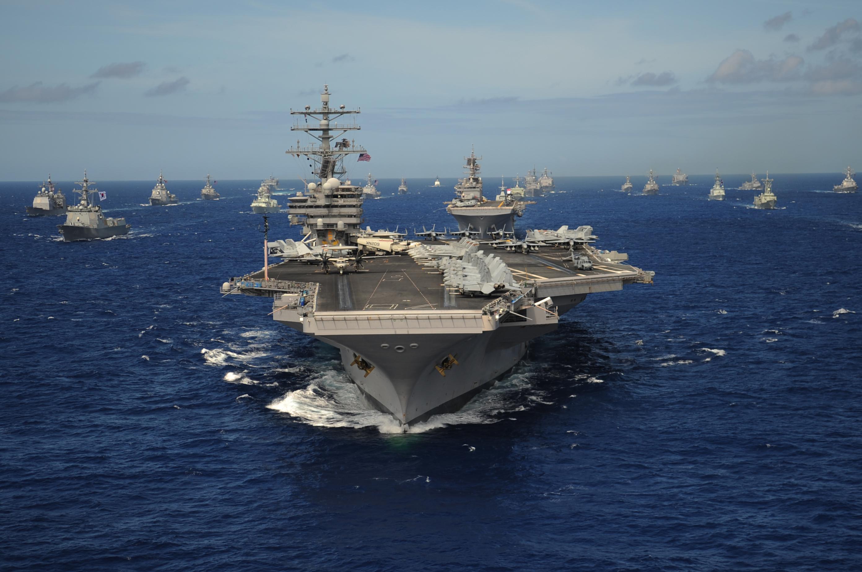 The Nimitzclass aircraft carrier USS Ronald Reagan leads a mass
