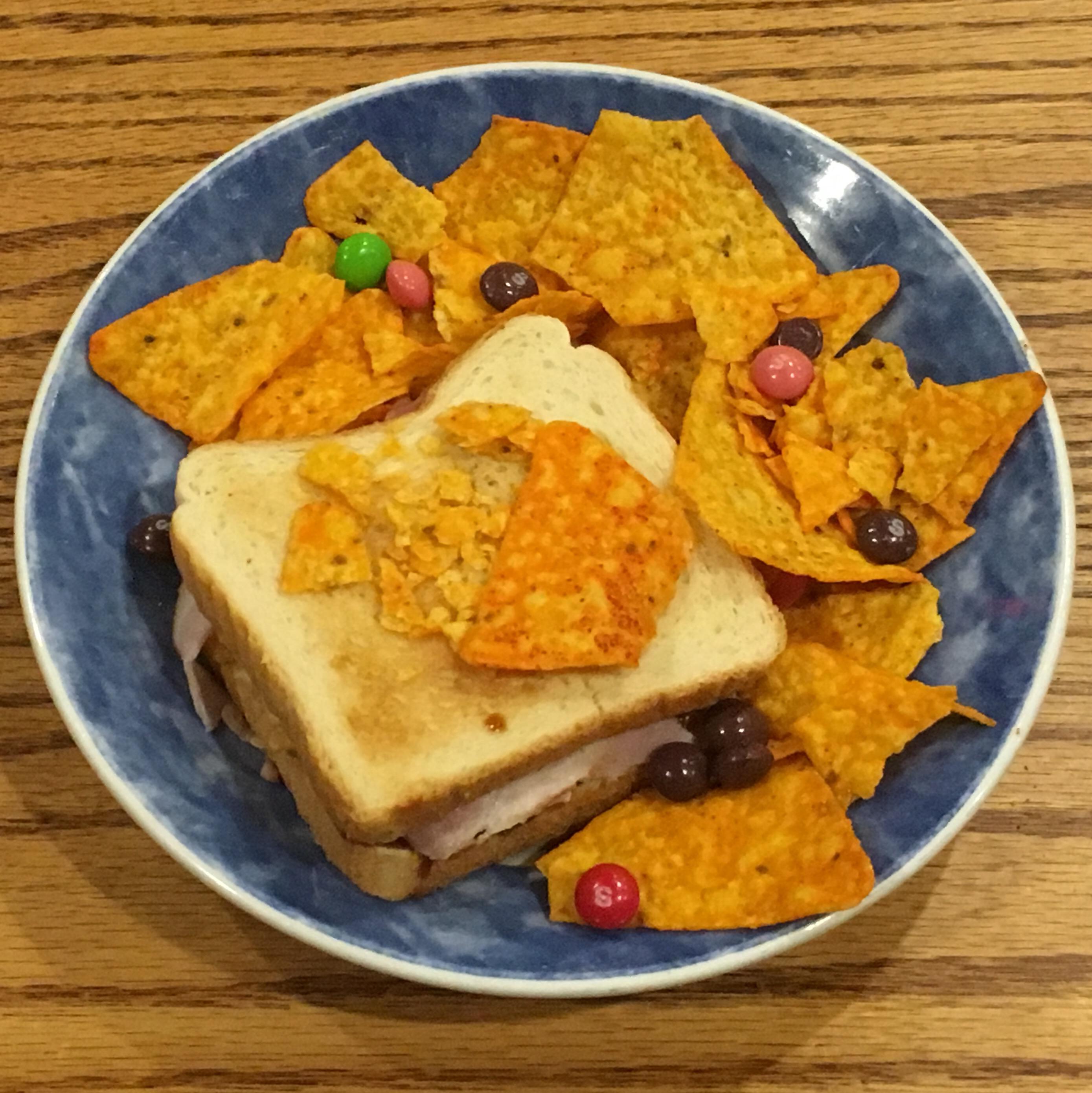 A sandwich consisting of ham, teriyaki, pickles and Fritos, with a