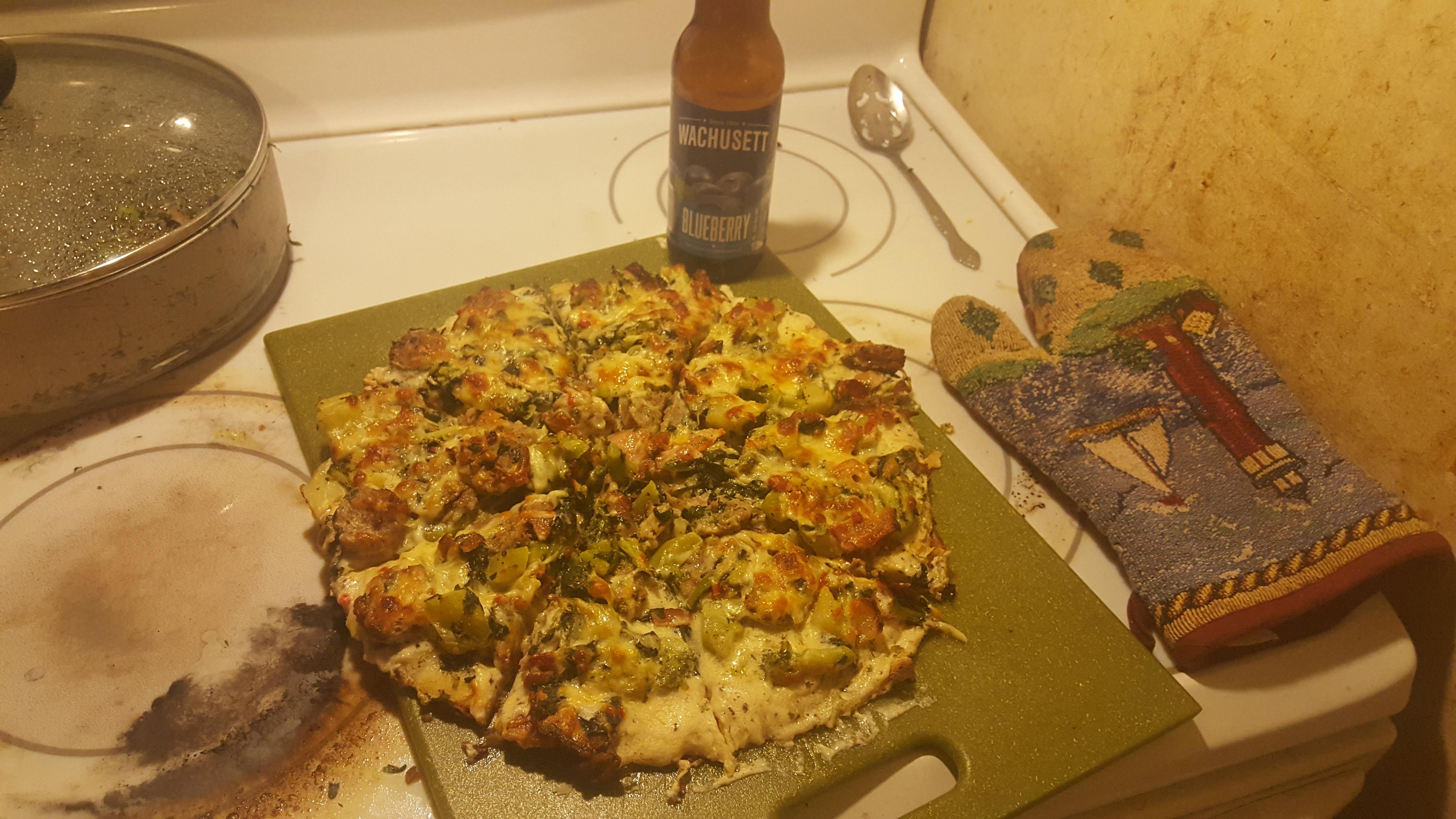 White sauce pizza with bratwurst, bacon, broccoli, spinach, and
