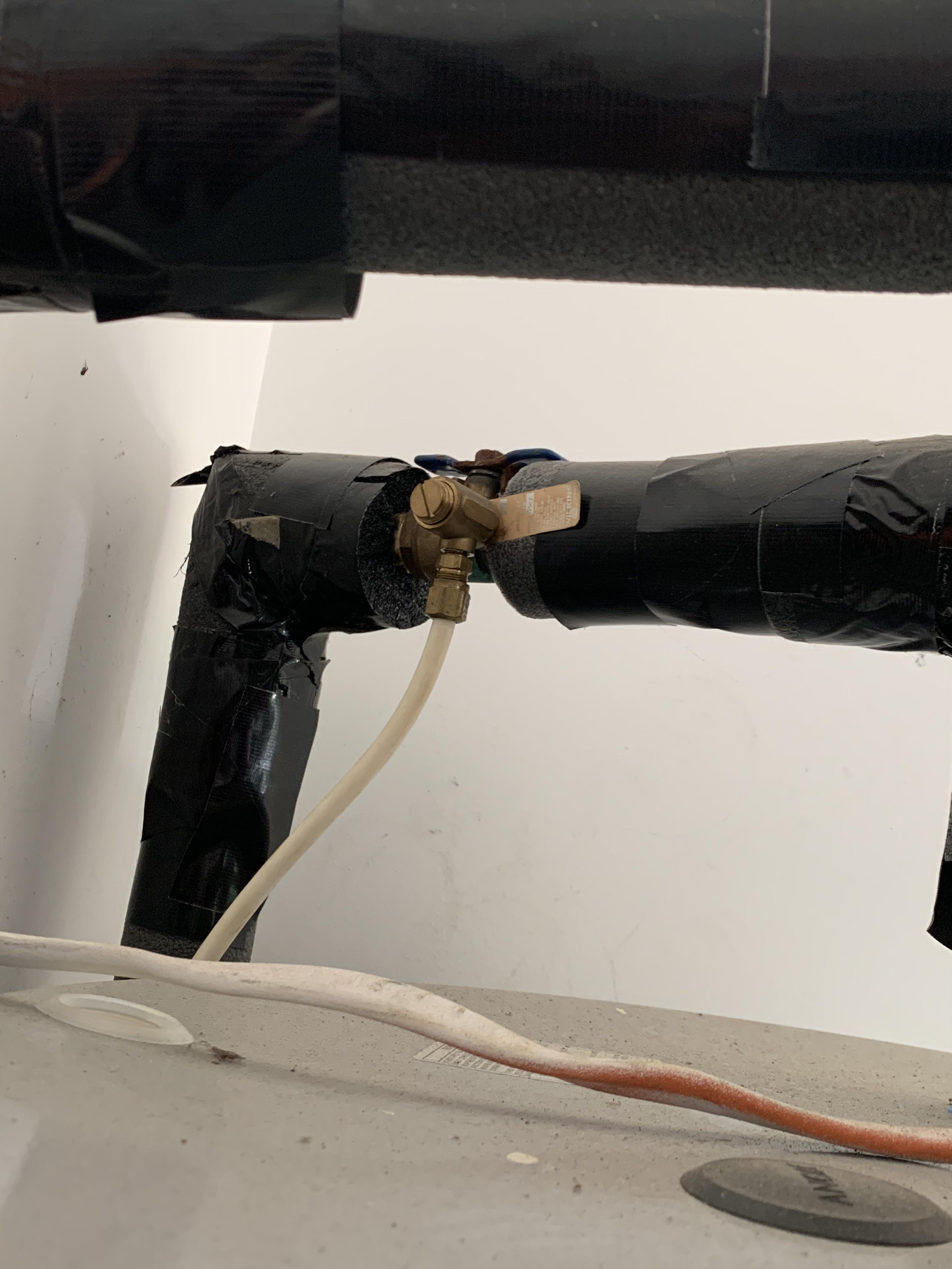 Drain line on cold water intake to water heater going outside with slow