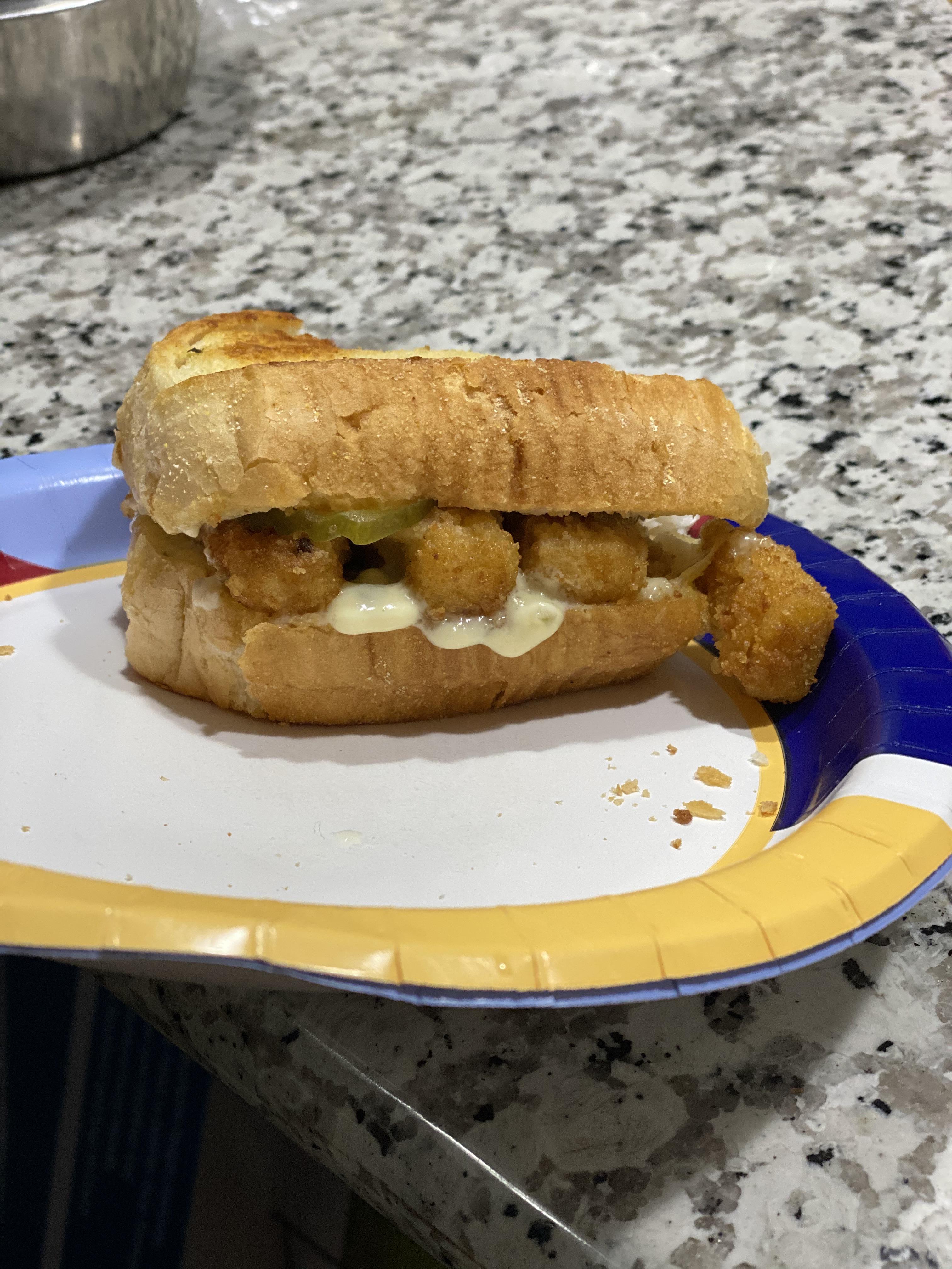 Fish stick sandwich with extra tartar sauce, pickles on Texas cheesy