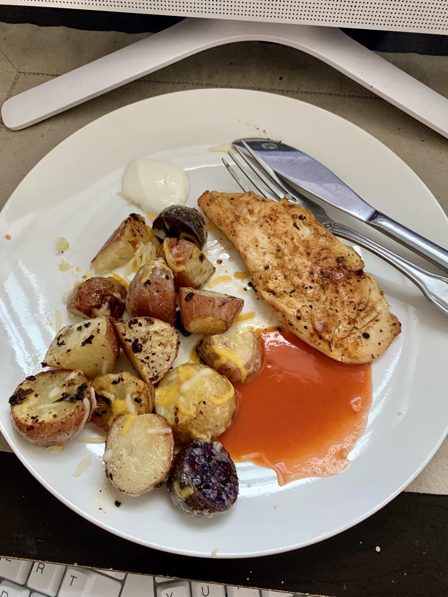 Baked chicken breast and baby potatoes with a sprinkle of cheese and