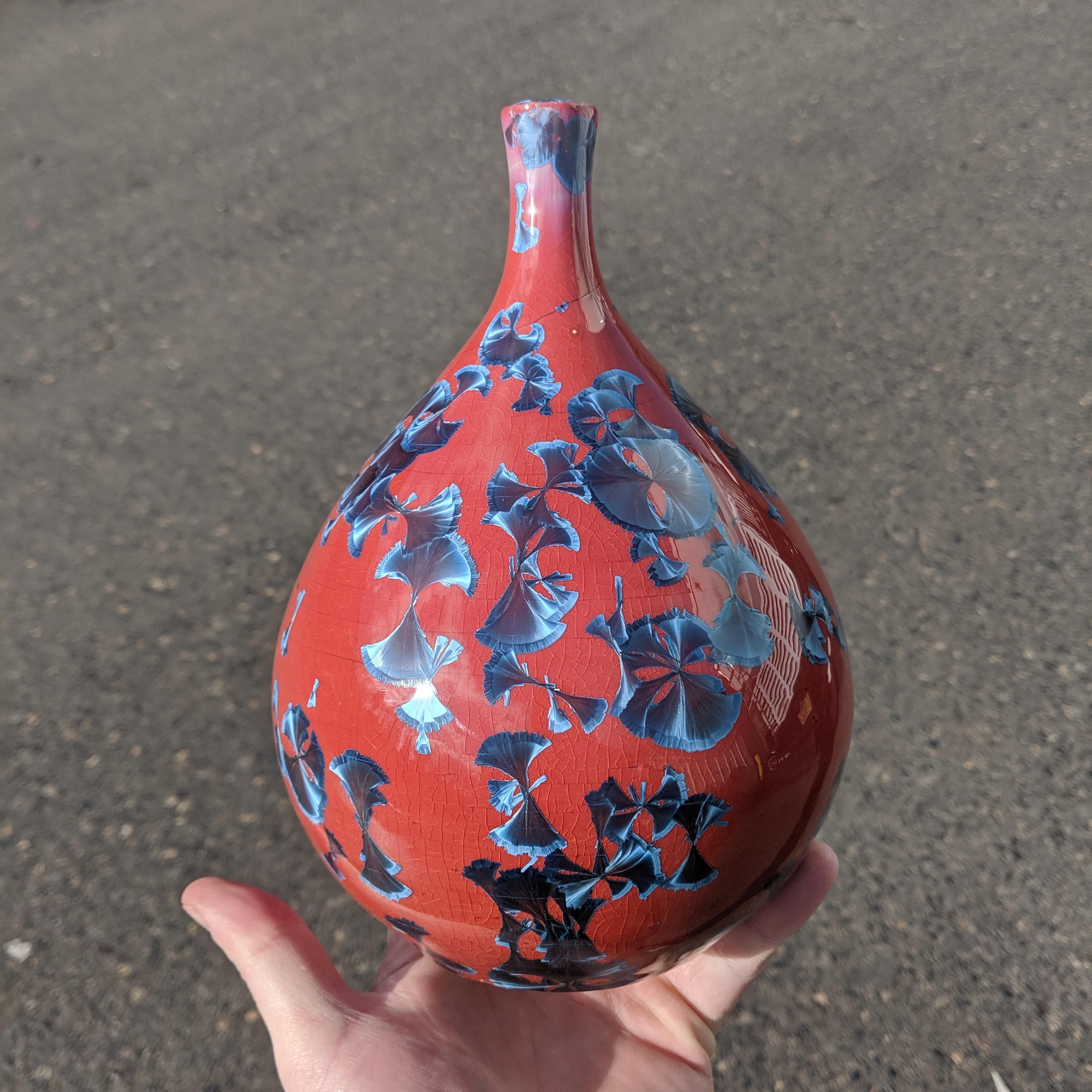 A cute little crystalline glazed bubbly thing. Nickel glaze over red