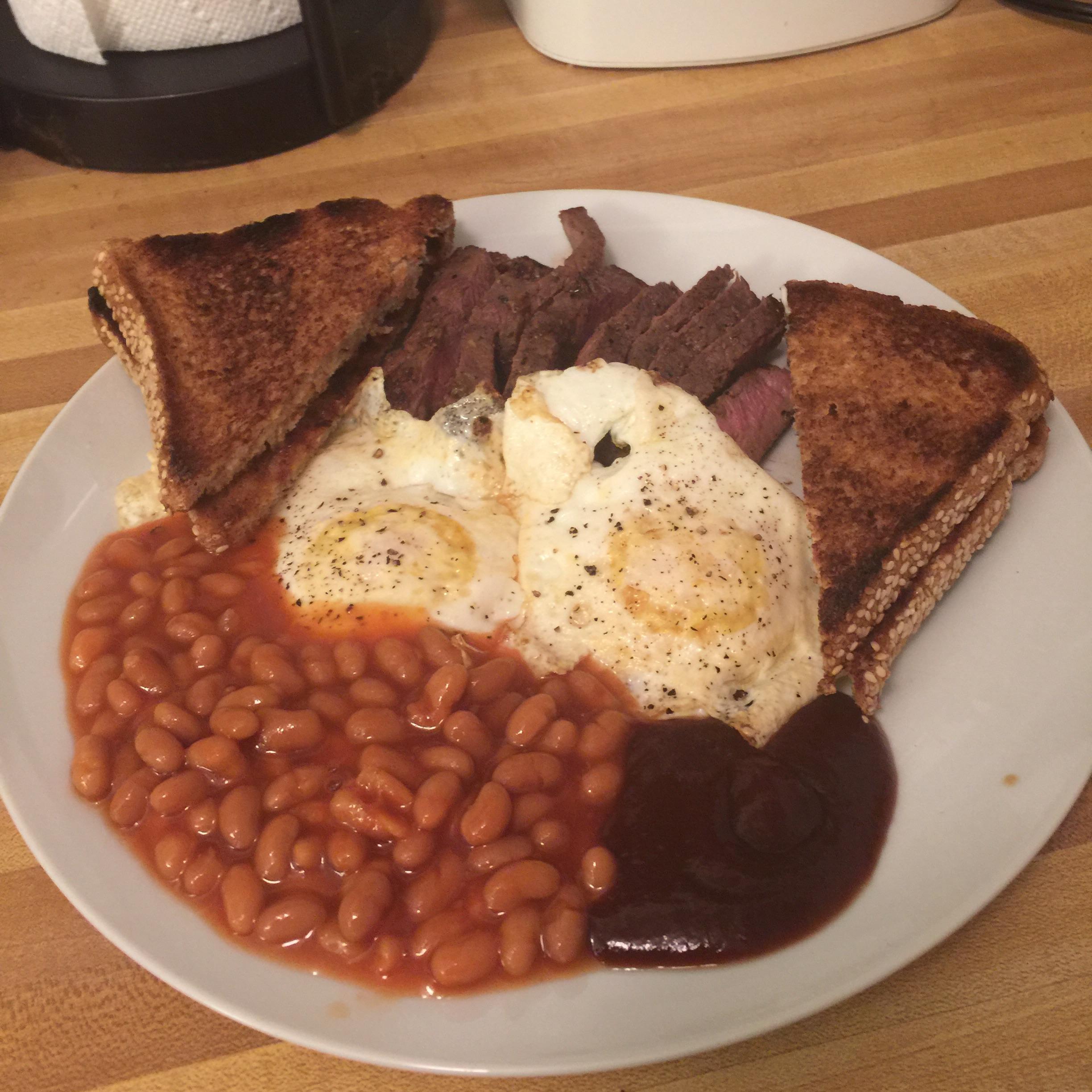 Breakfast for dinner... two over easy eggs with steak, beans, and toast. r/PutAnEggOnIt
