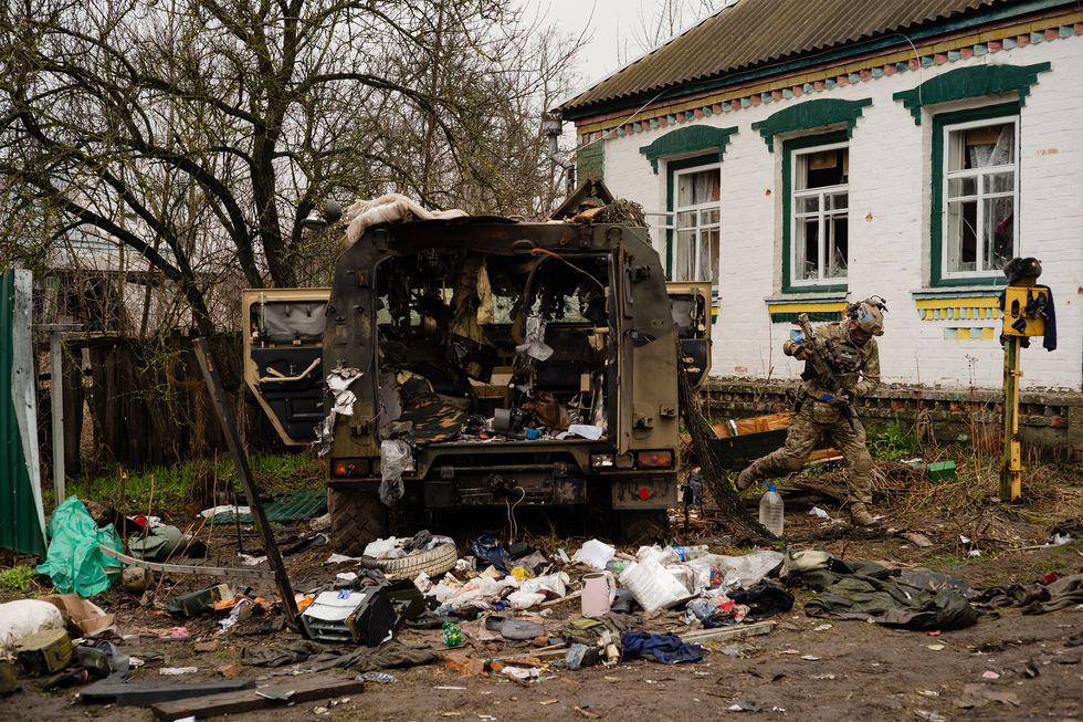 After inspecting a damaged Russian armored vehicle, a Ukrainian soldier