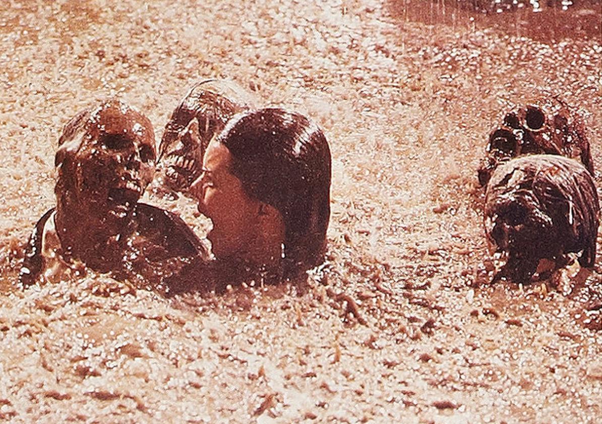 A still of JoBeth Williams in the water with some skeletons in