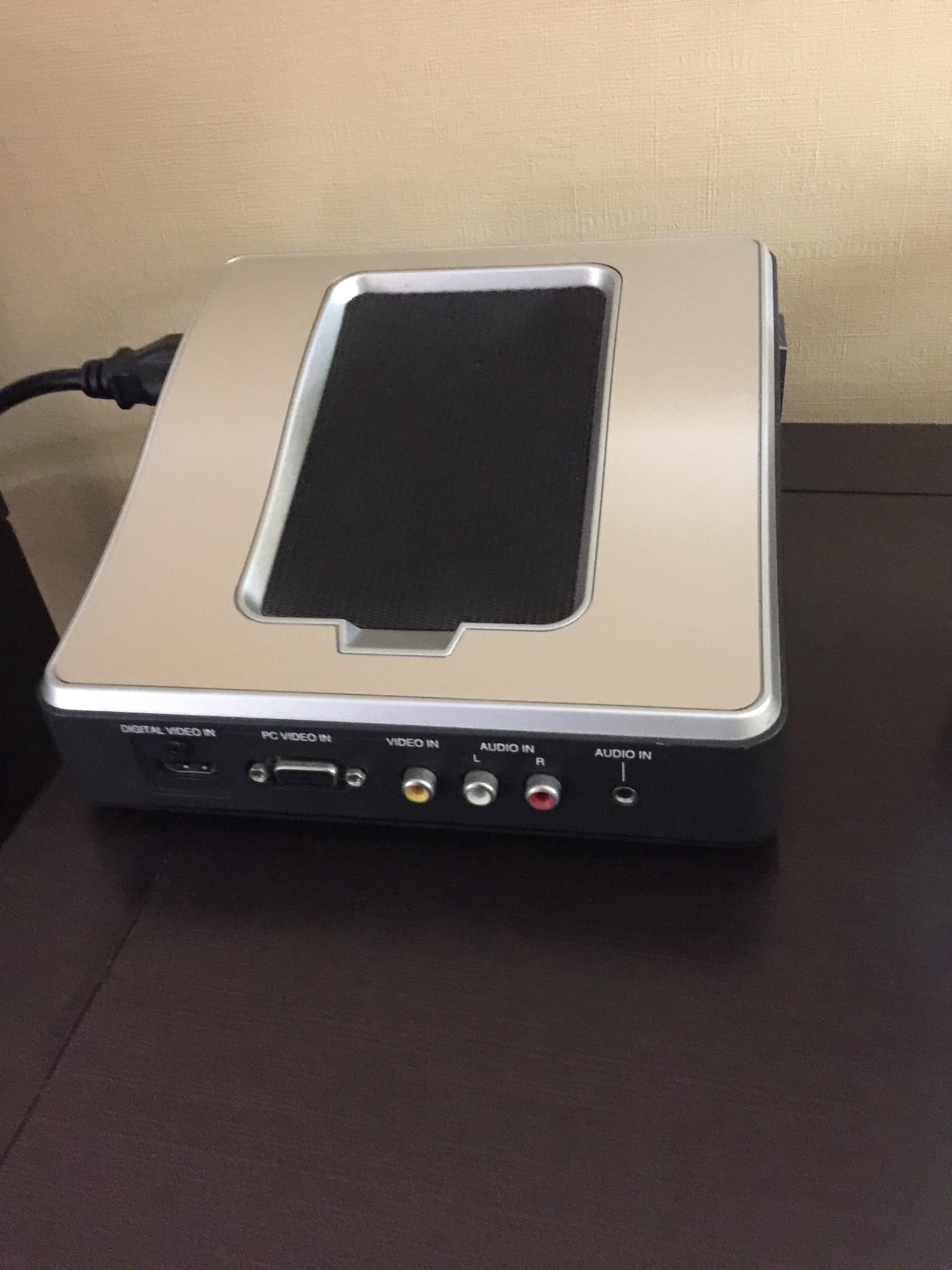 Unknown electronic device. Coffee maker is plugged into it. Two cords