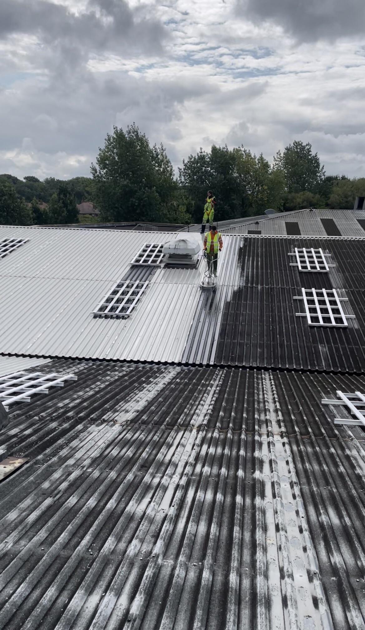 Industrial roof cleaning using a rotary surface cleaner and hot water