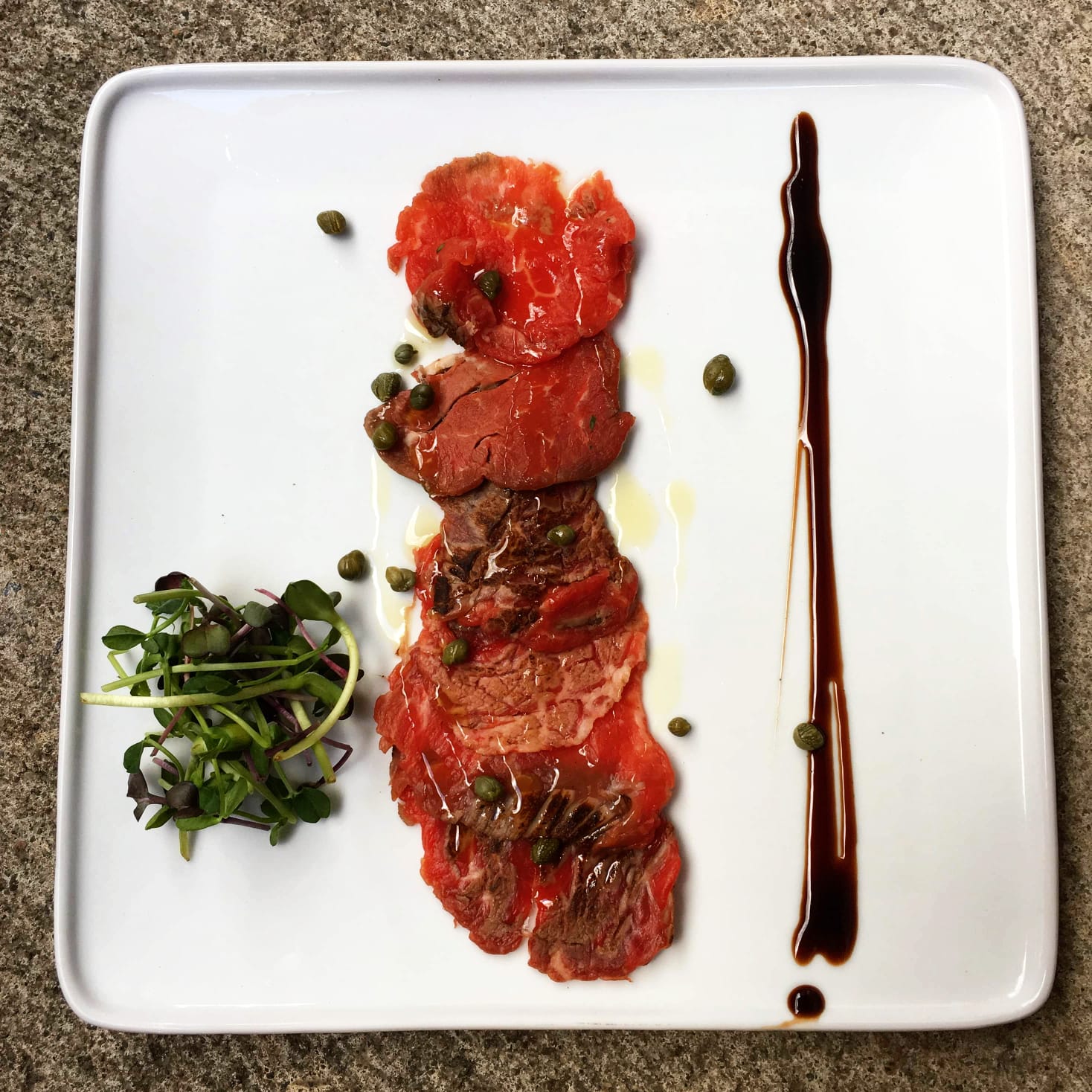 Elk Carpaccio with truffle oil, capers, greens and balsamic r