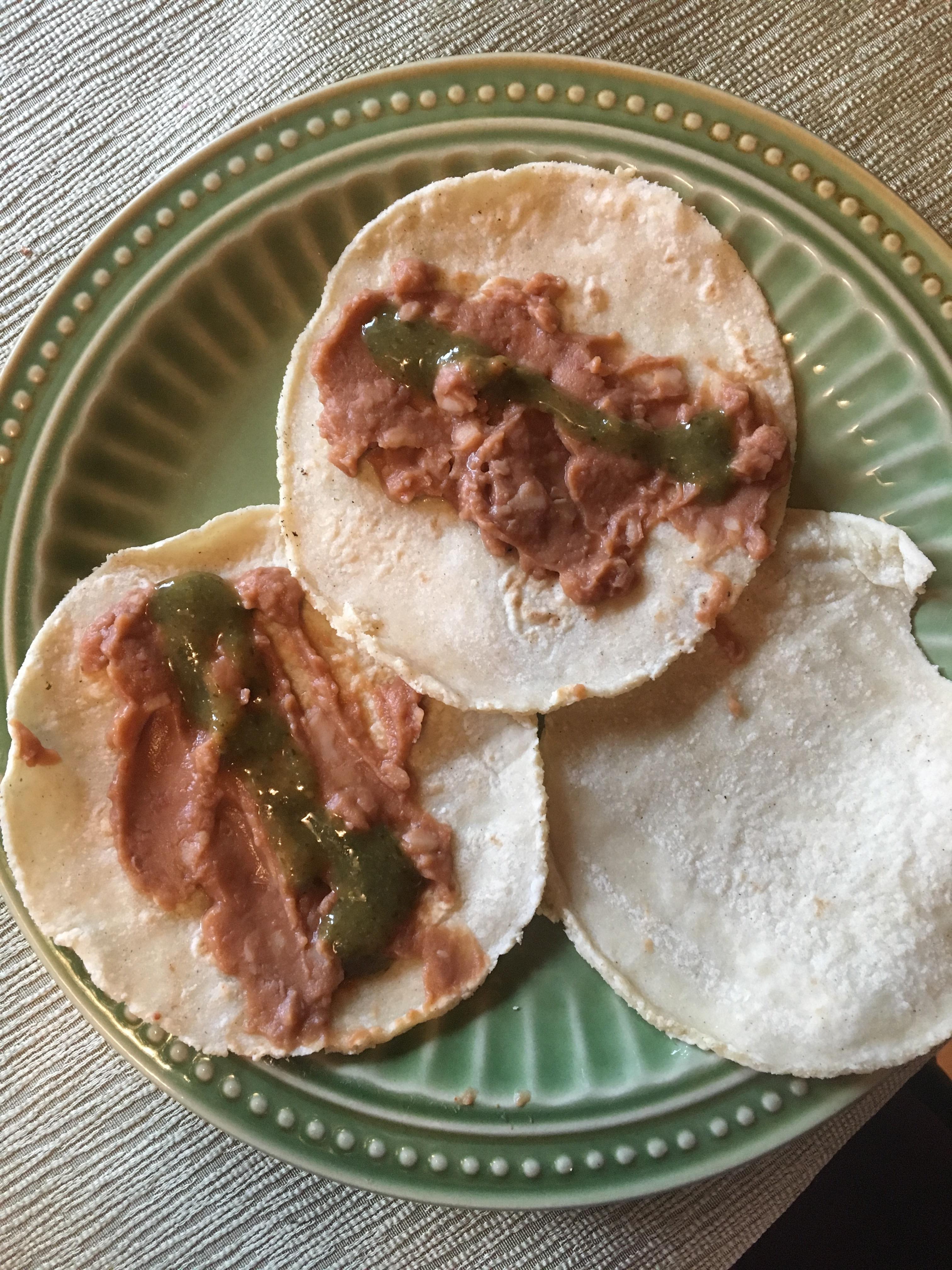 Corn tortillas + refried beans + trader joe's green dragon hot sauce