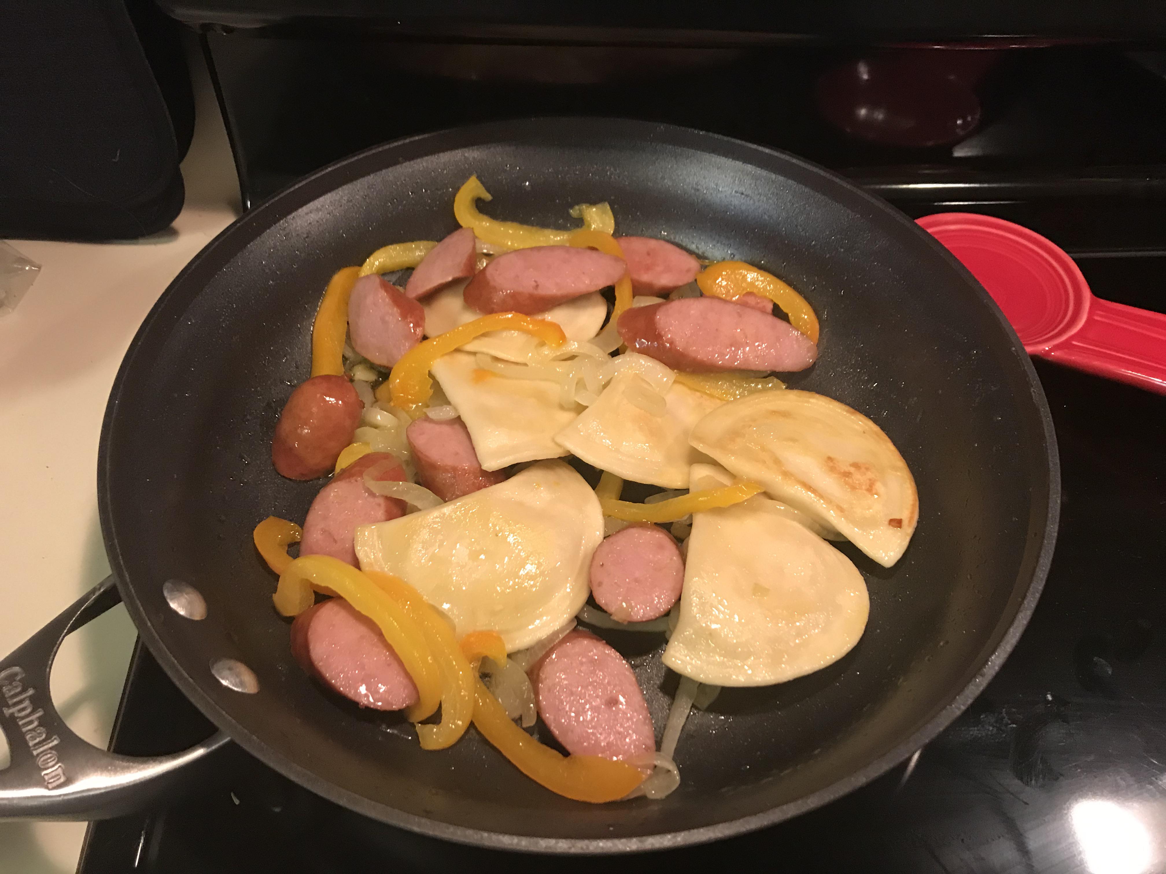 Pierogis and kielbasa sausage with sliced onion and bell pepper r