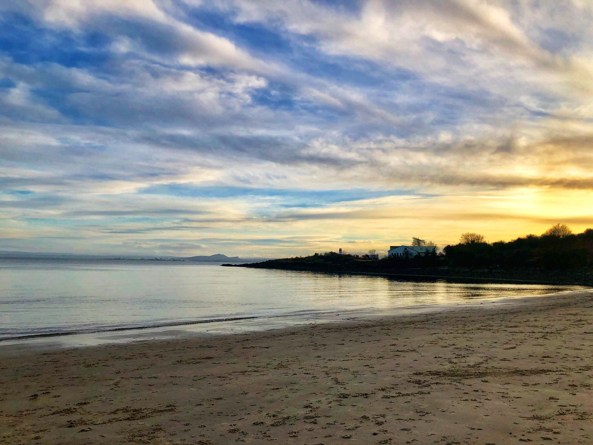 Aberdour beach in Fife, Scotland over looking Arthur’s Seat in the