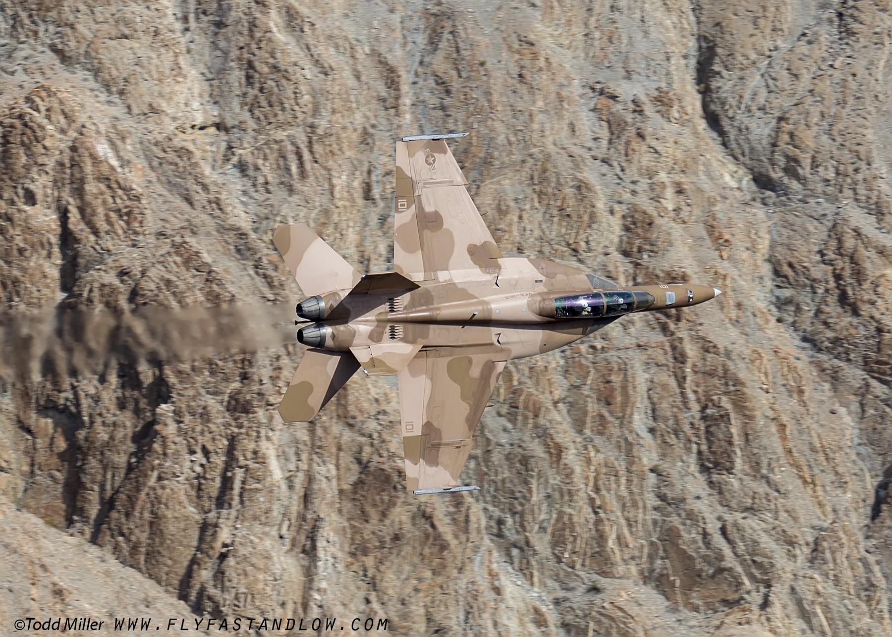 A US Navy F/A18F sporting brown camo performs a low pass through