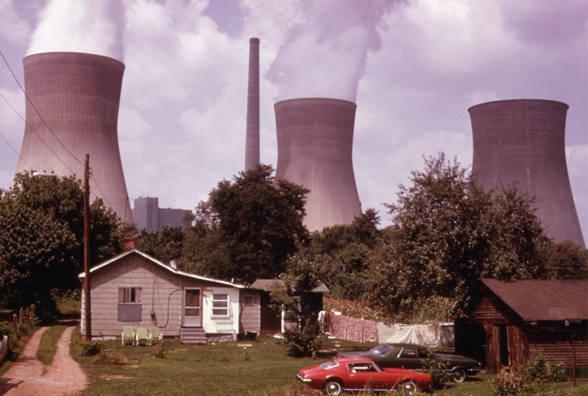 Water cooling towers of the John Amos Power Plant loom over a home located across the Kanawha