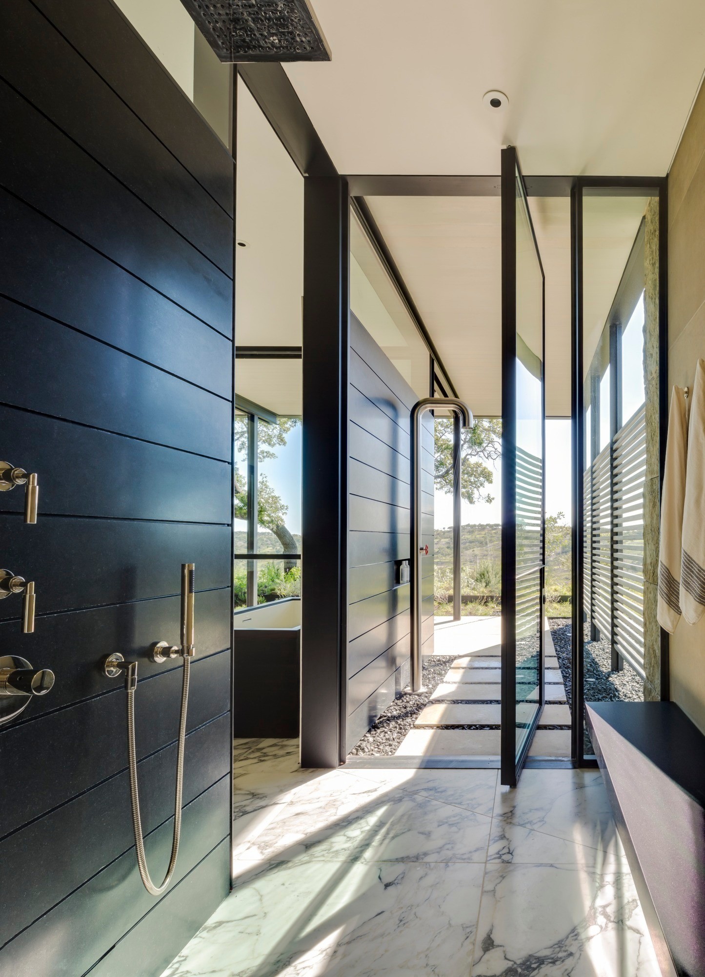 Indoor/outdoor shower is divided by a pivoting glass door in this home in Center Point, Texas