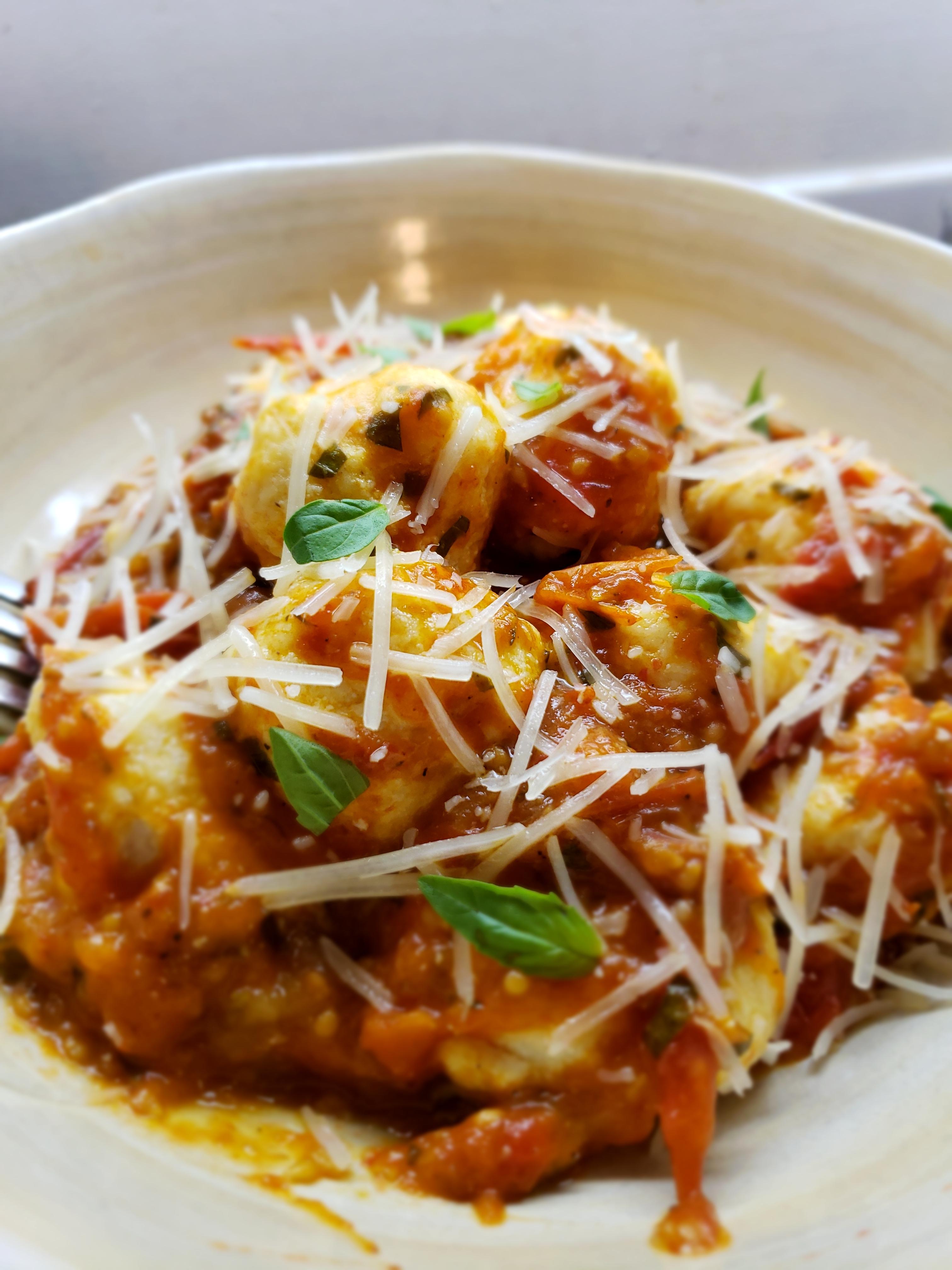 Homemade ricotta dumplings with a roasted heirloom tomato and basil