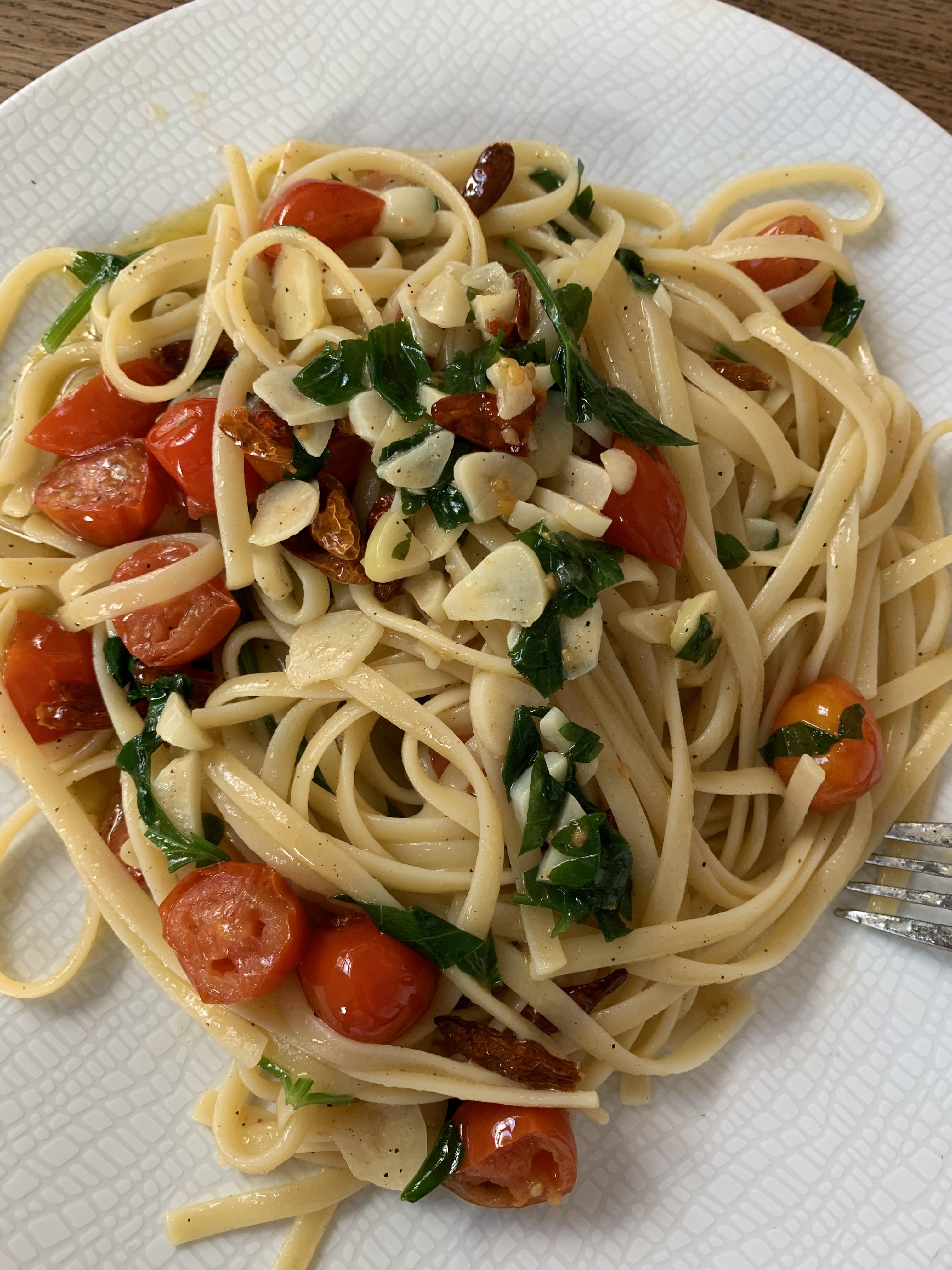 Pasta linguine with olive oil, garlic, butter, cherry tomatoes, parsley, chili and a bit of salt